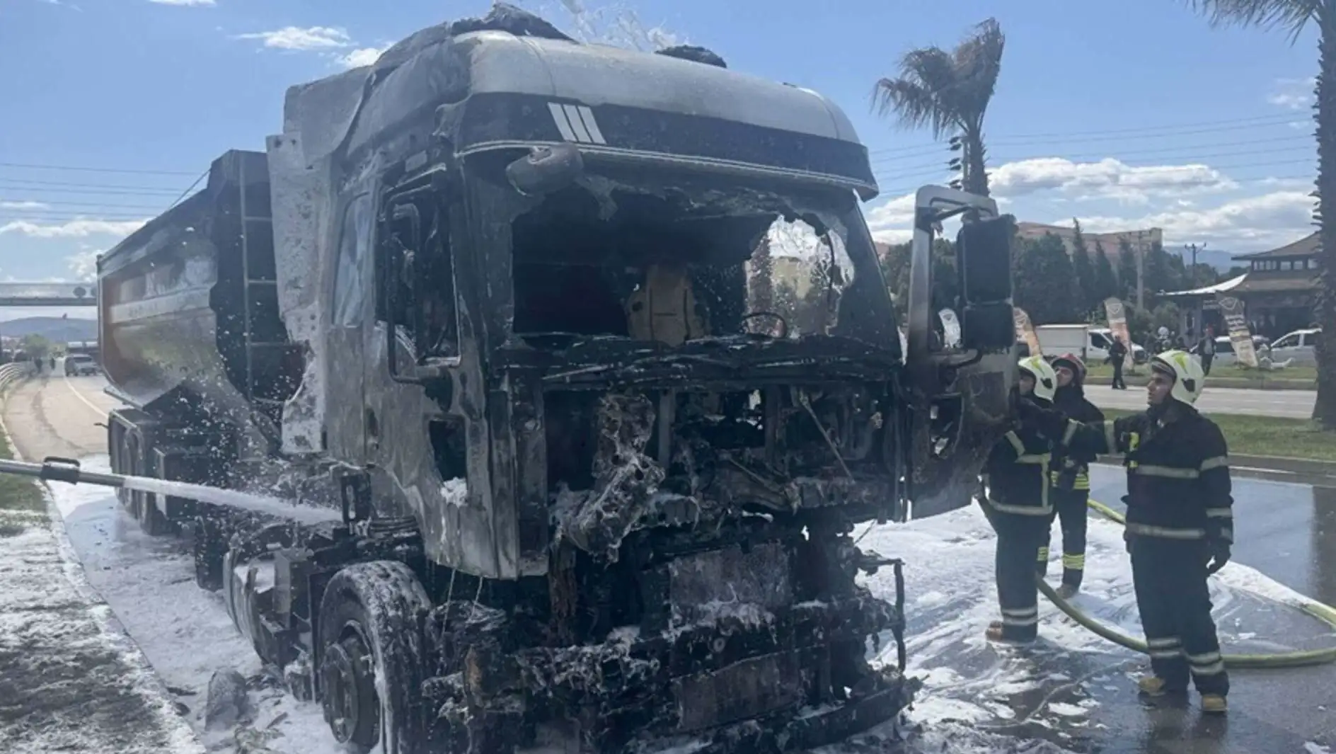 A fireman standing next to a burnt truck A fireman standing next to a burnt truck