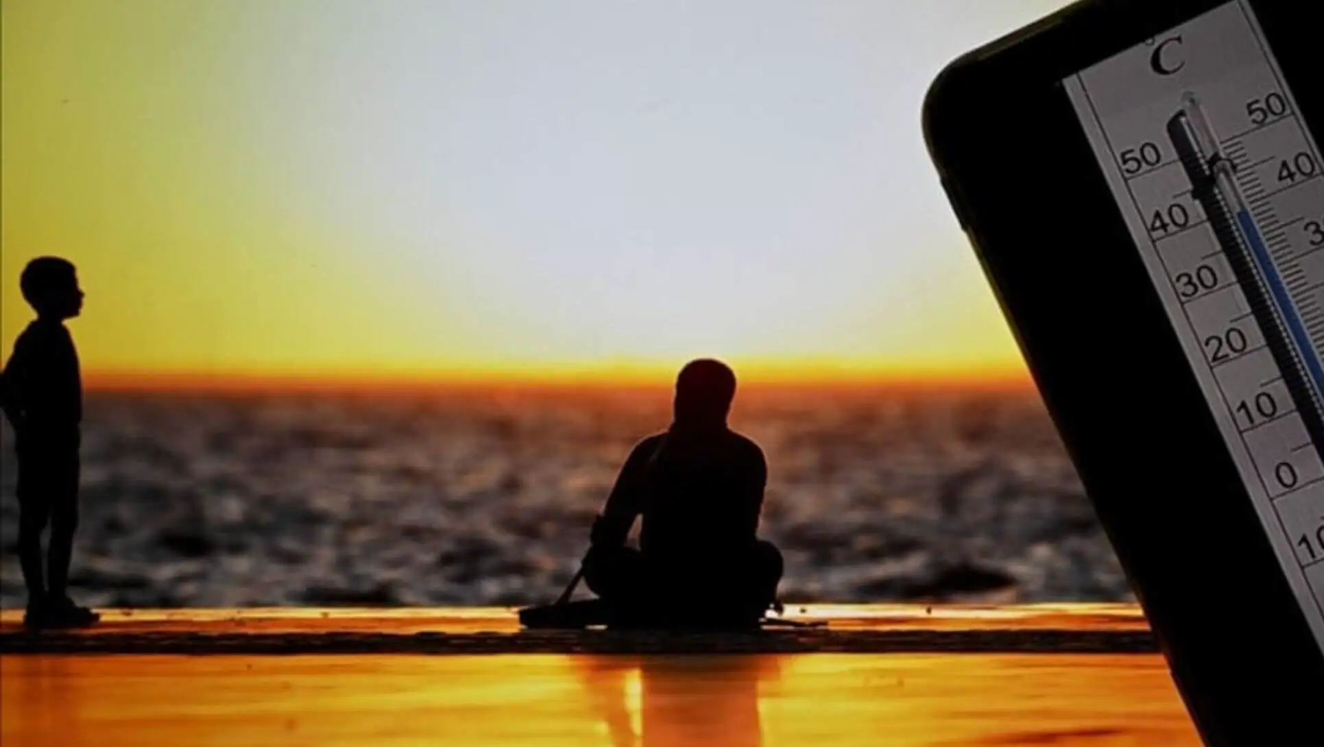 A person sitting on the beach in hot weather. A person sitting on the beach in hot weather.