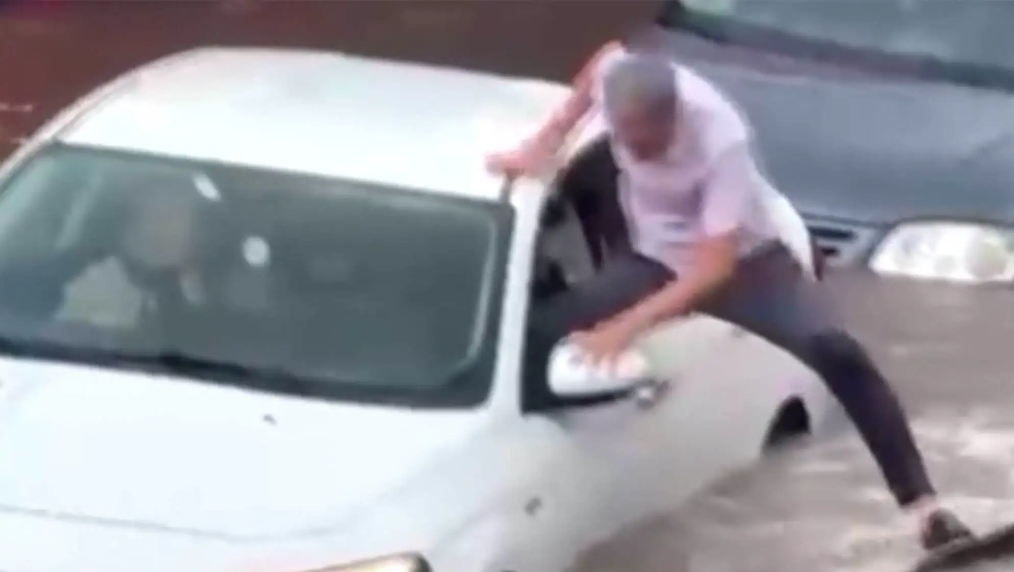 A man trying to climb out of a car during the flood. A man trying to climb out of a car during the flood.