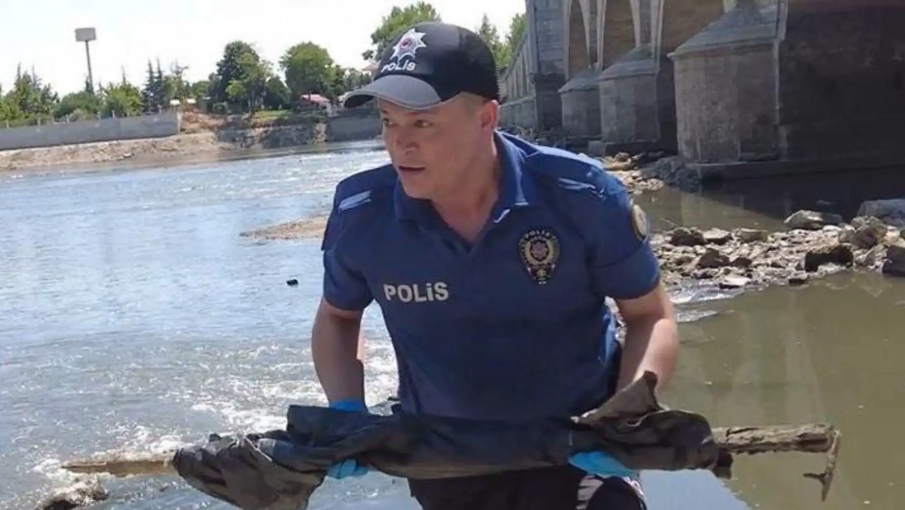 Meriç Nehri'nde bir adam, nehir önünde bir çanta tutuyor.