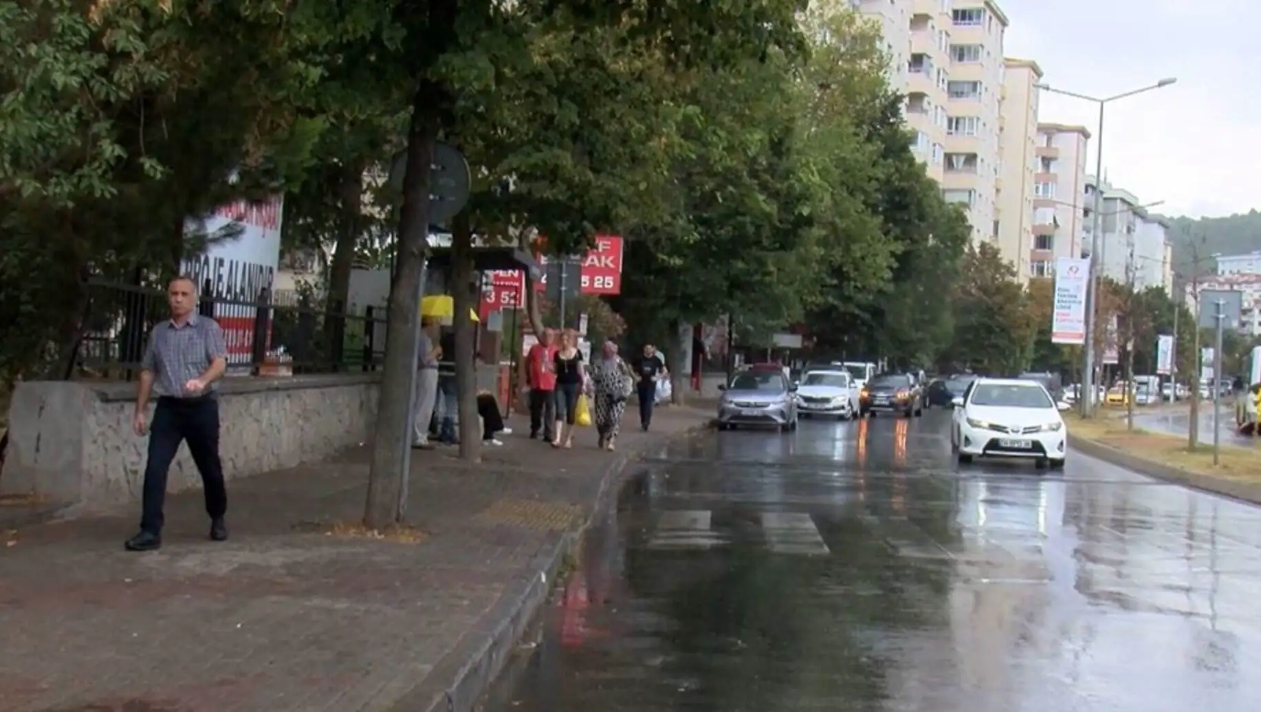 Yağmurda yürüyen bir grup insan.