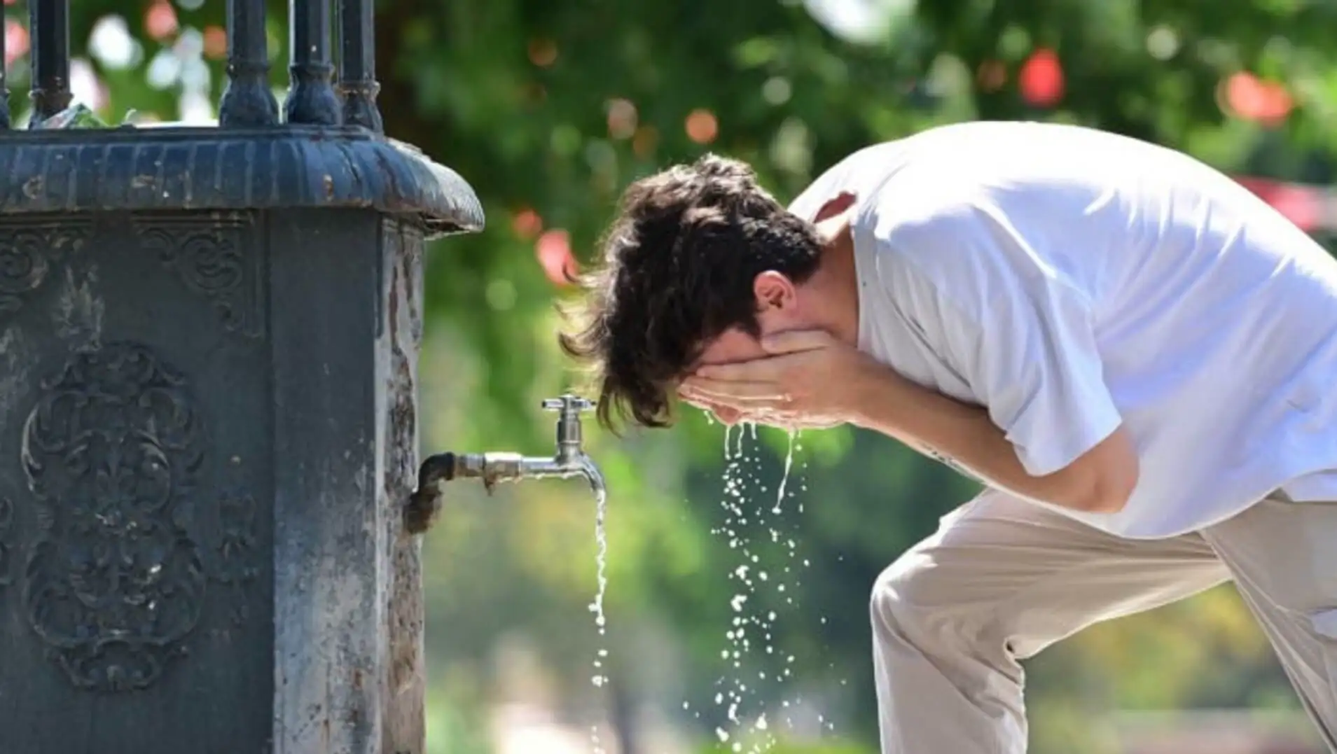 A man standing in front of a faucet. A man standing in front of a faucet.