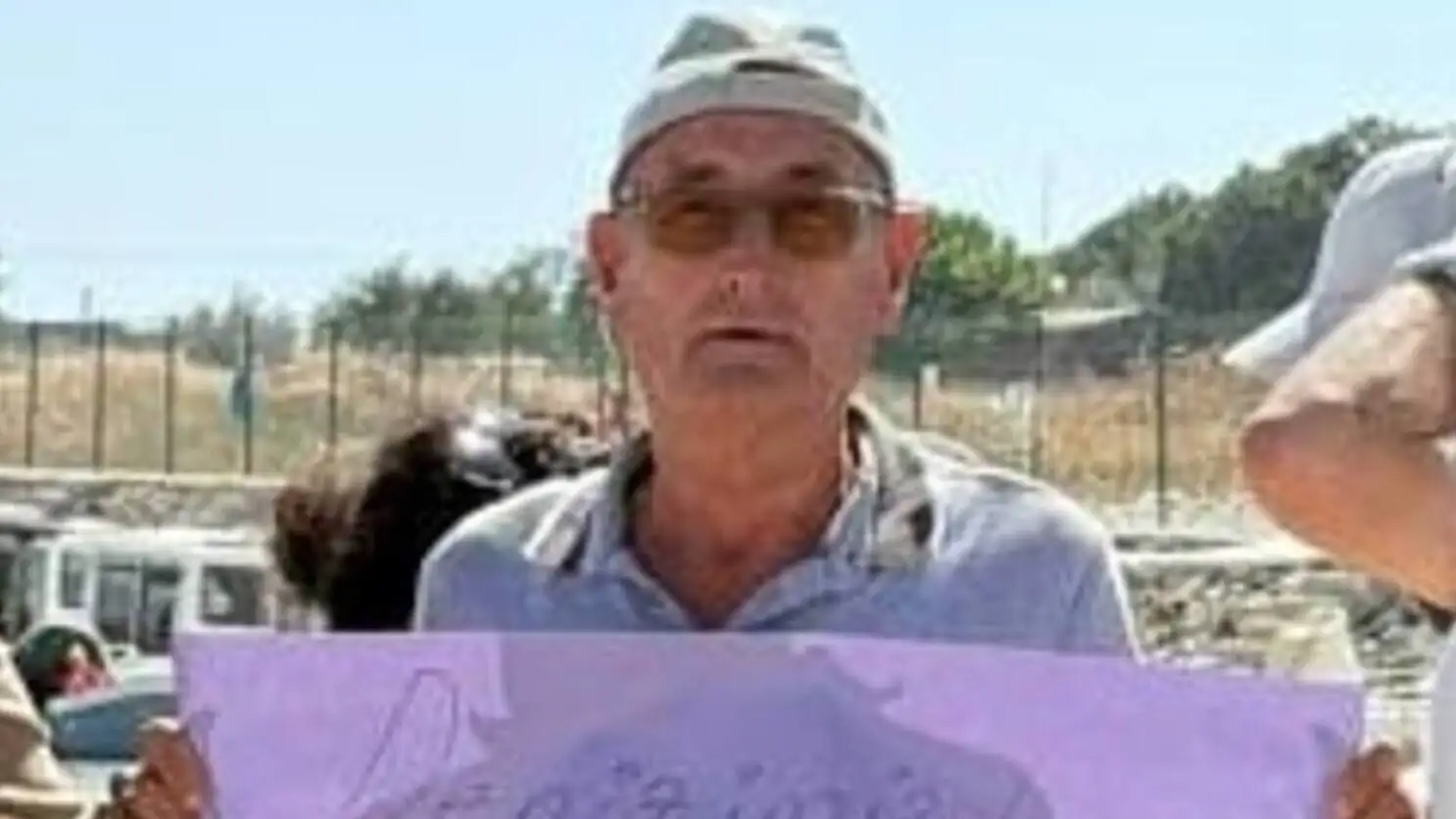 Bir adam pankart tutarak protesto ediyor. Bir adam pankart tutarak protesto ediyor.