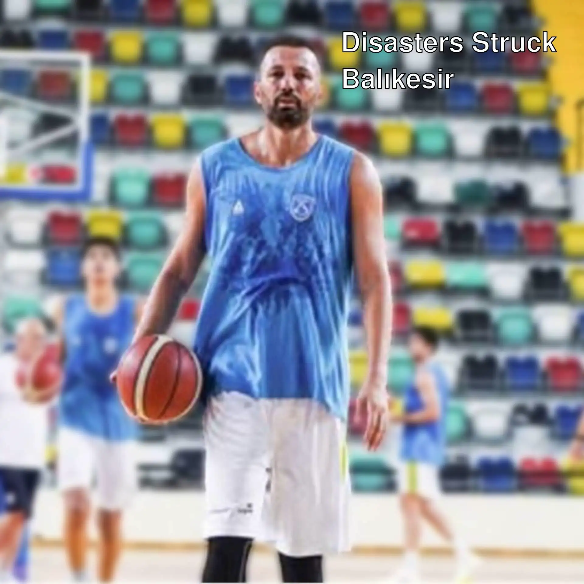 A man holding a basketball in front of other people in a basketball court. A man holding a basketball in front of other people in a basketball court.