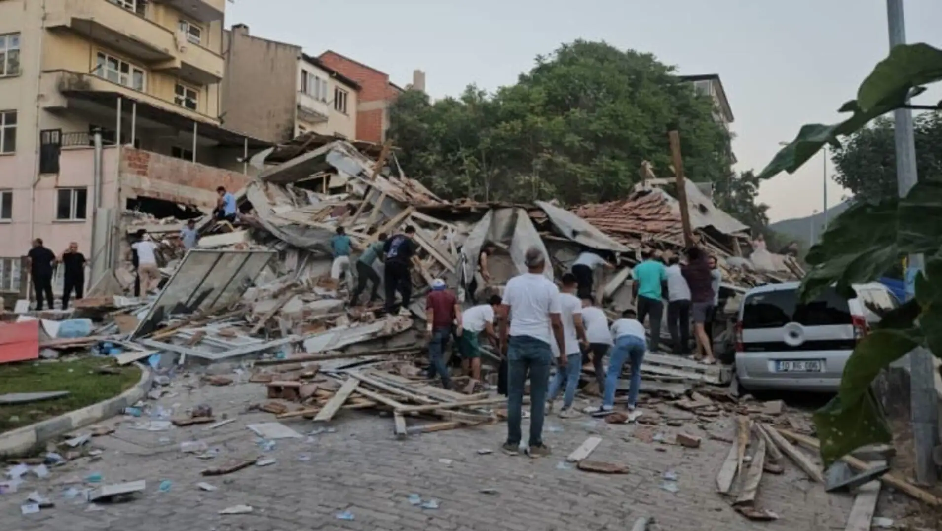 People standing around a collapsed building. People standing around a collapsed building.