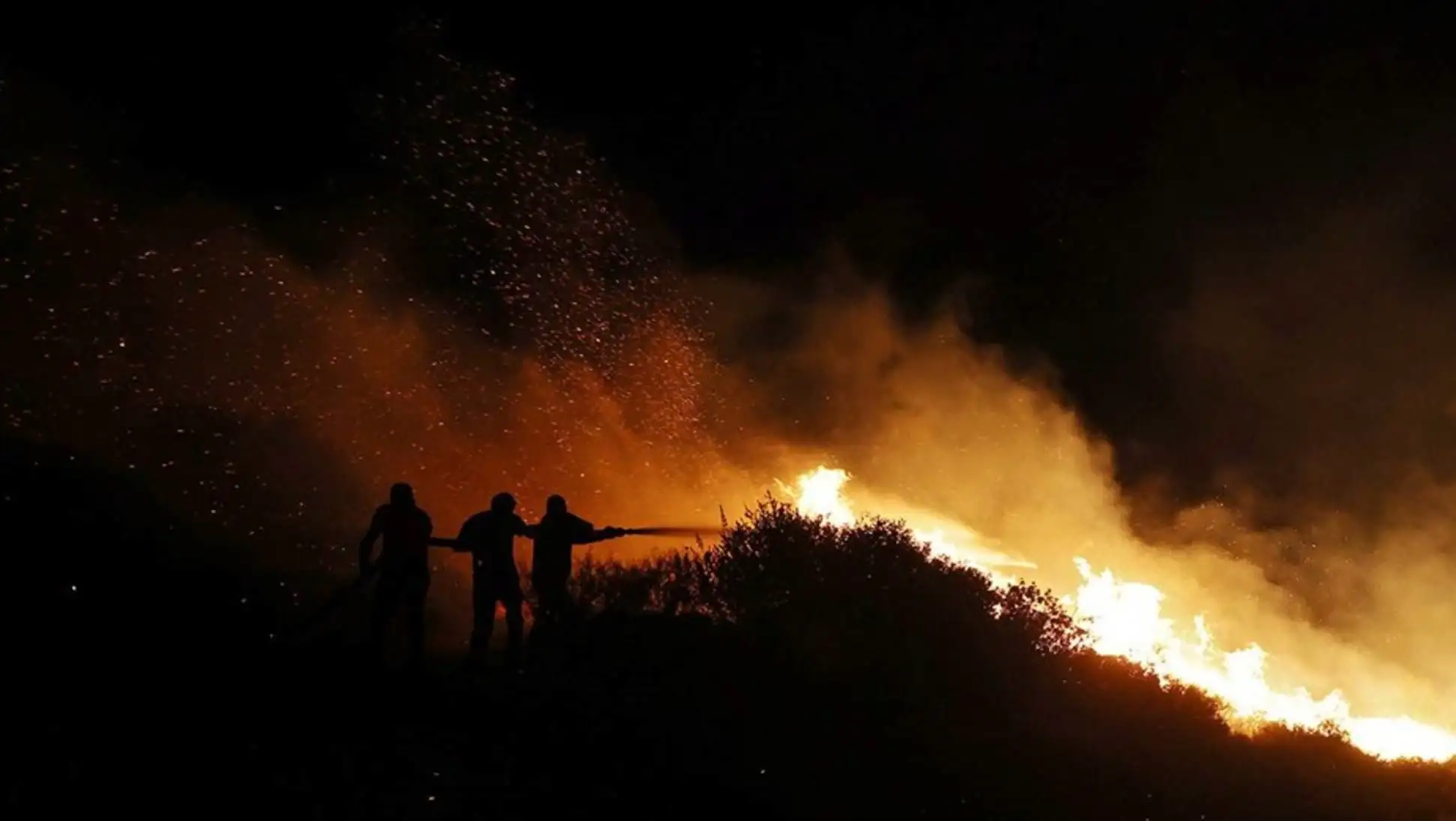 A group of people fighting a fire. A group of people fighting a fire.