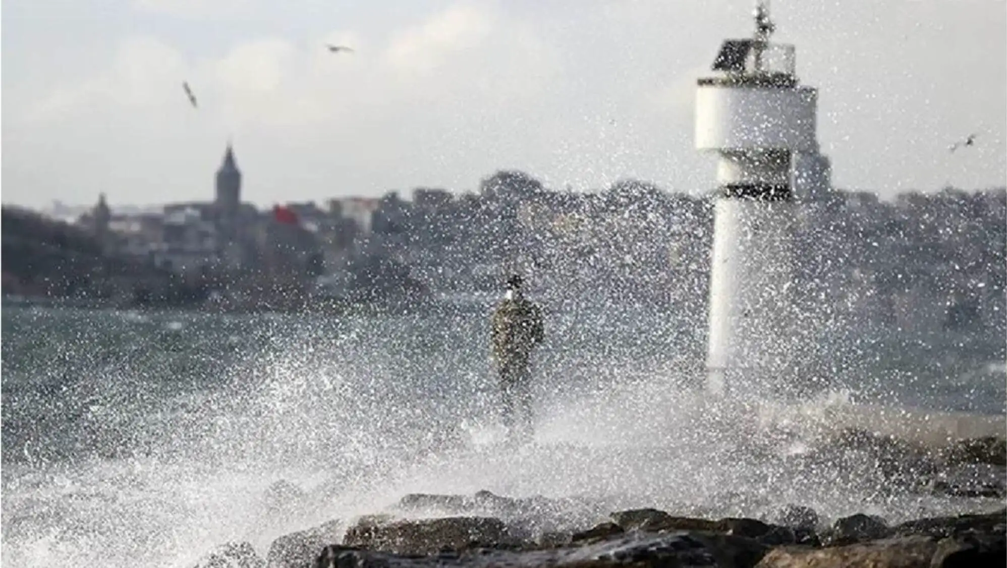 A person standing on rocks with water splashing. A person standing on rocks with water splashing.