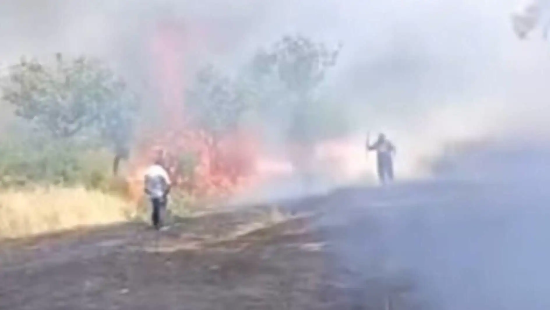A group of people walking on a dirt road with smoke. A group of people walking on a dirt road with smoke.