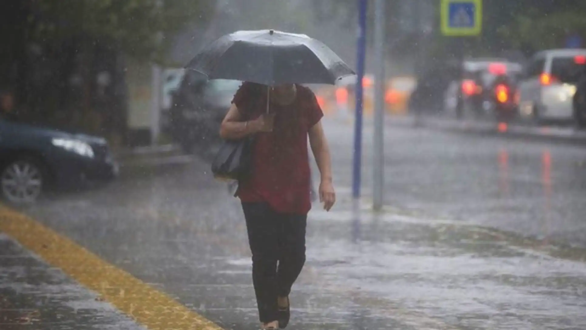 A person walking in the rain with an umbrella. A person walking in the rain with an umbrella.