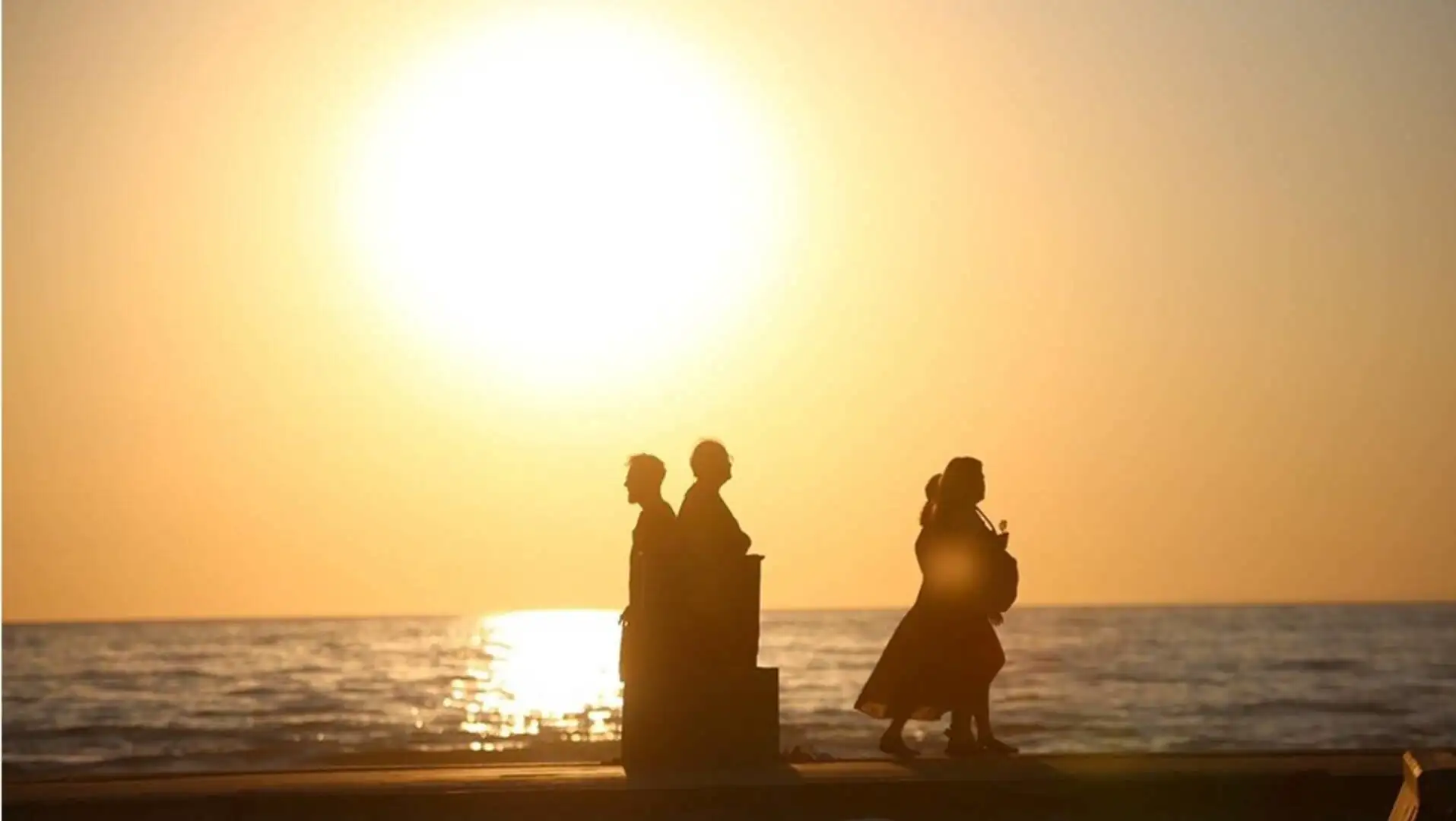 A group of people walking on a beach. A group of people walking on a beach.