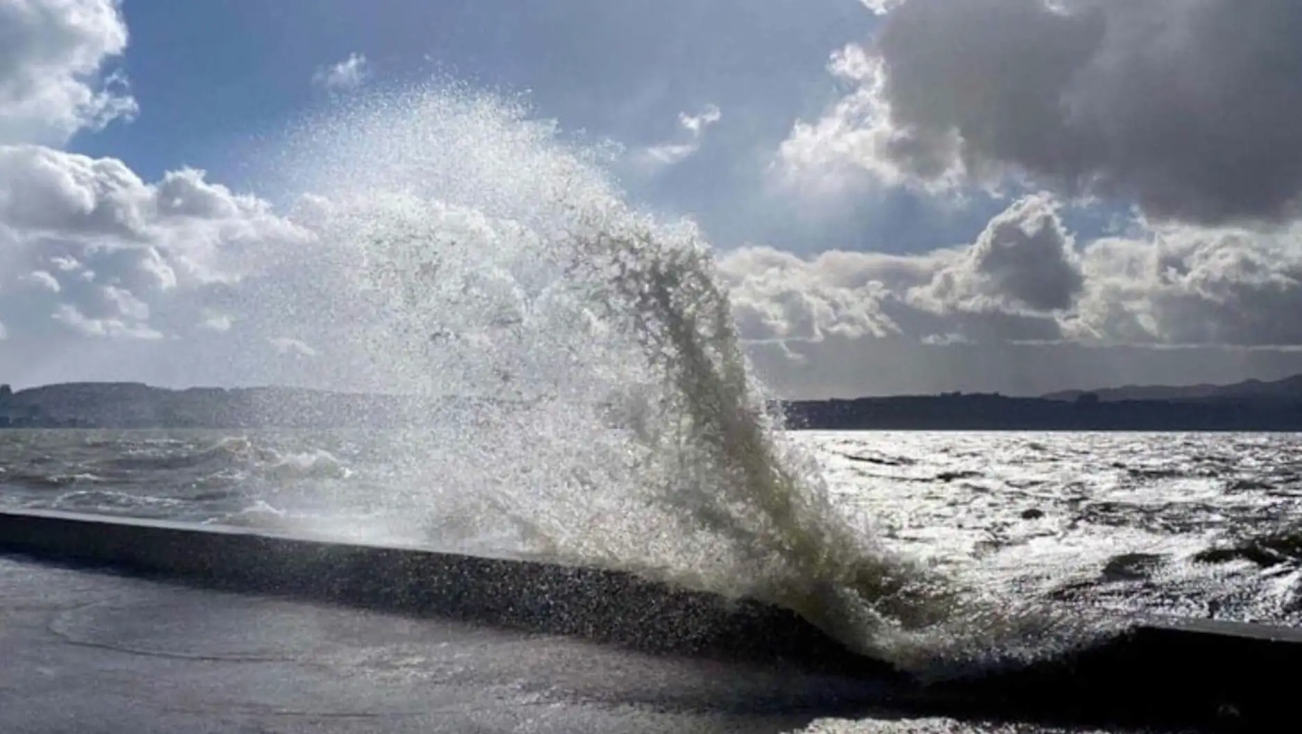 Waves crashing against a wall during a storm.