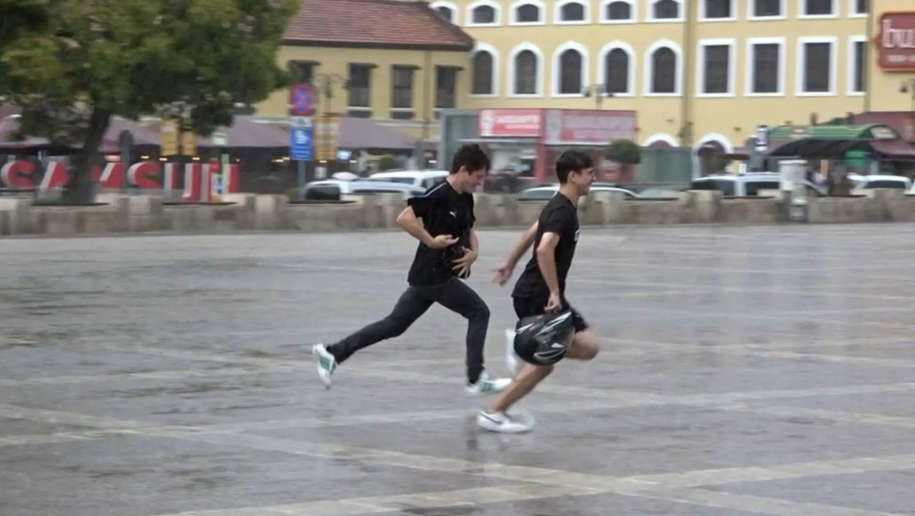 Two men running in the rain.