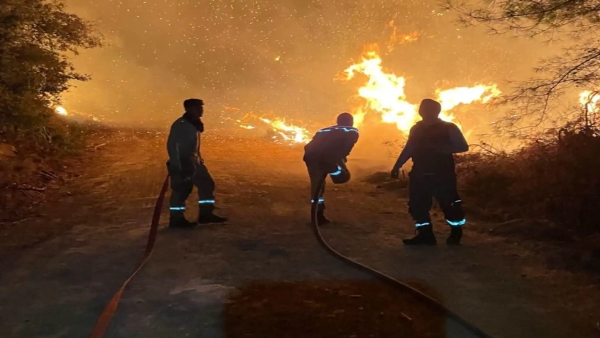 A group of firefighters trying to extinguish a fire. A group of firefighters trying to extinguish a fire.