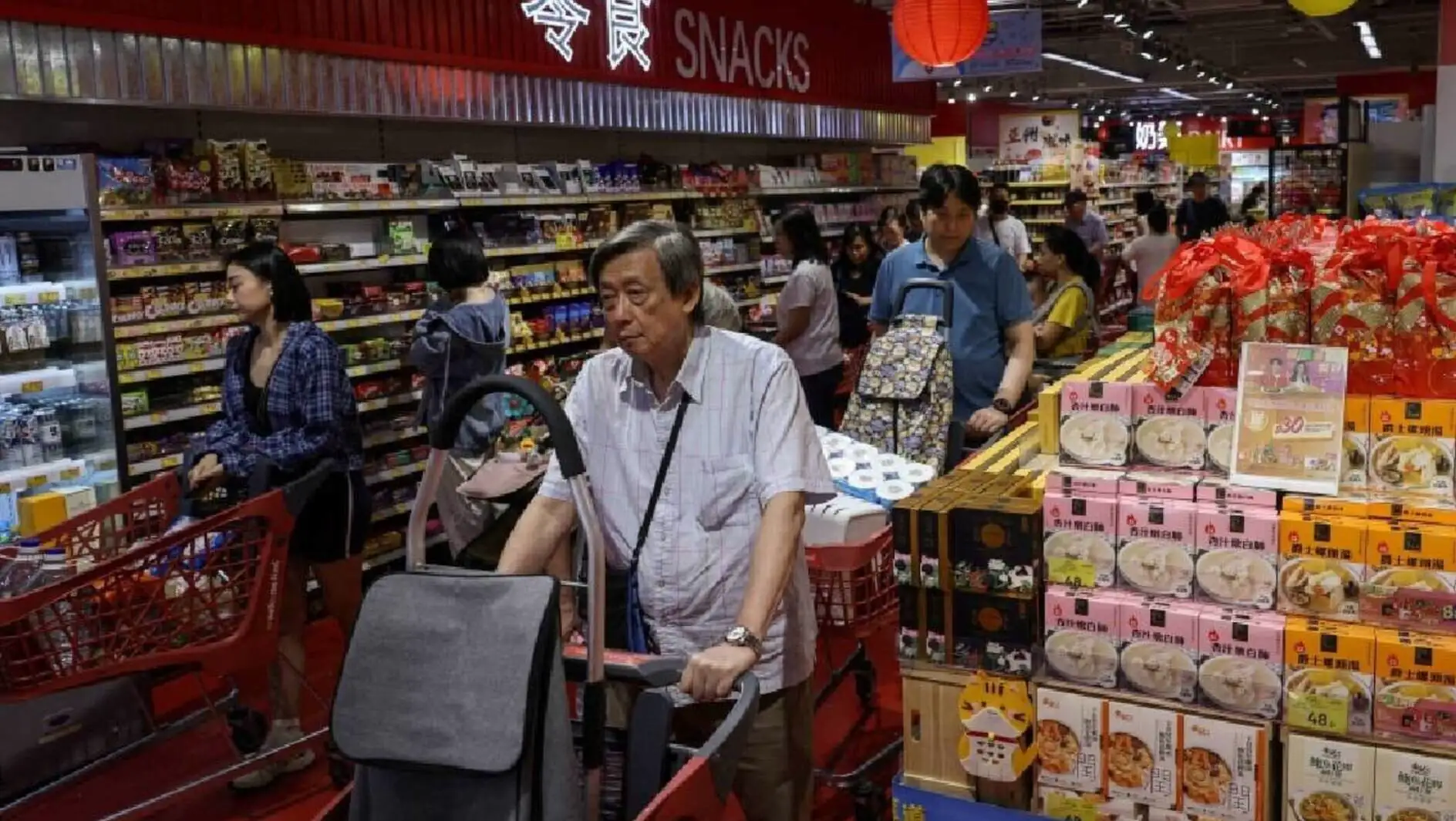 A group of people shopping in a grocery store.