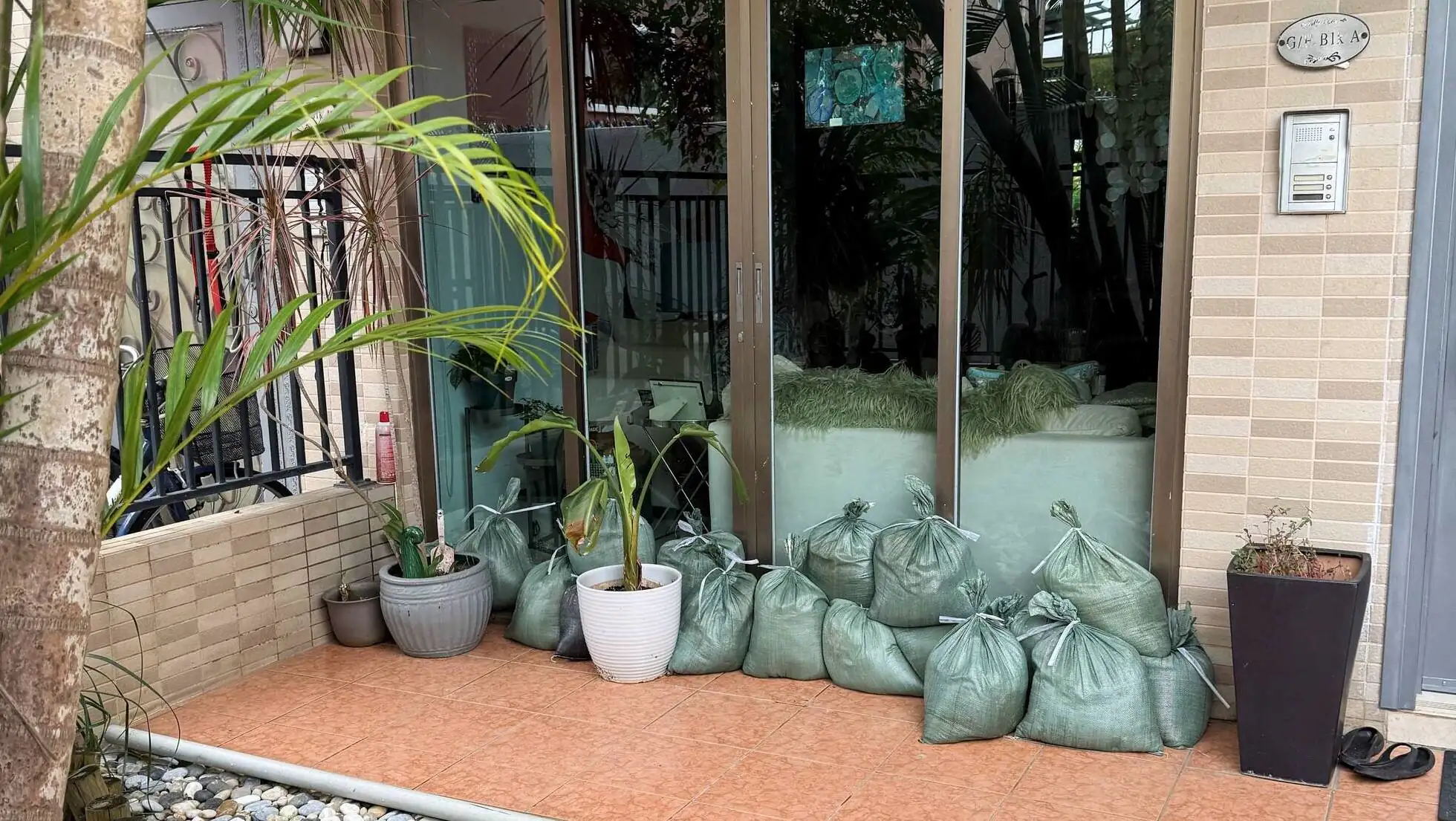A group of bags of dirt outside a building.