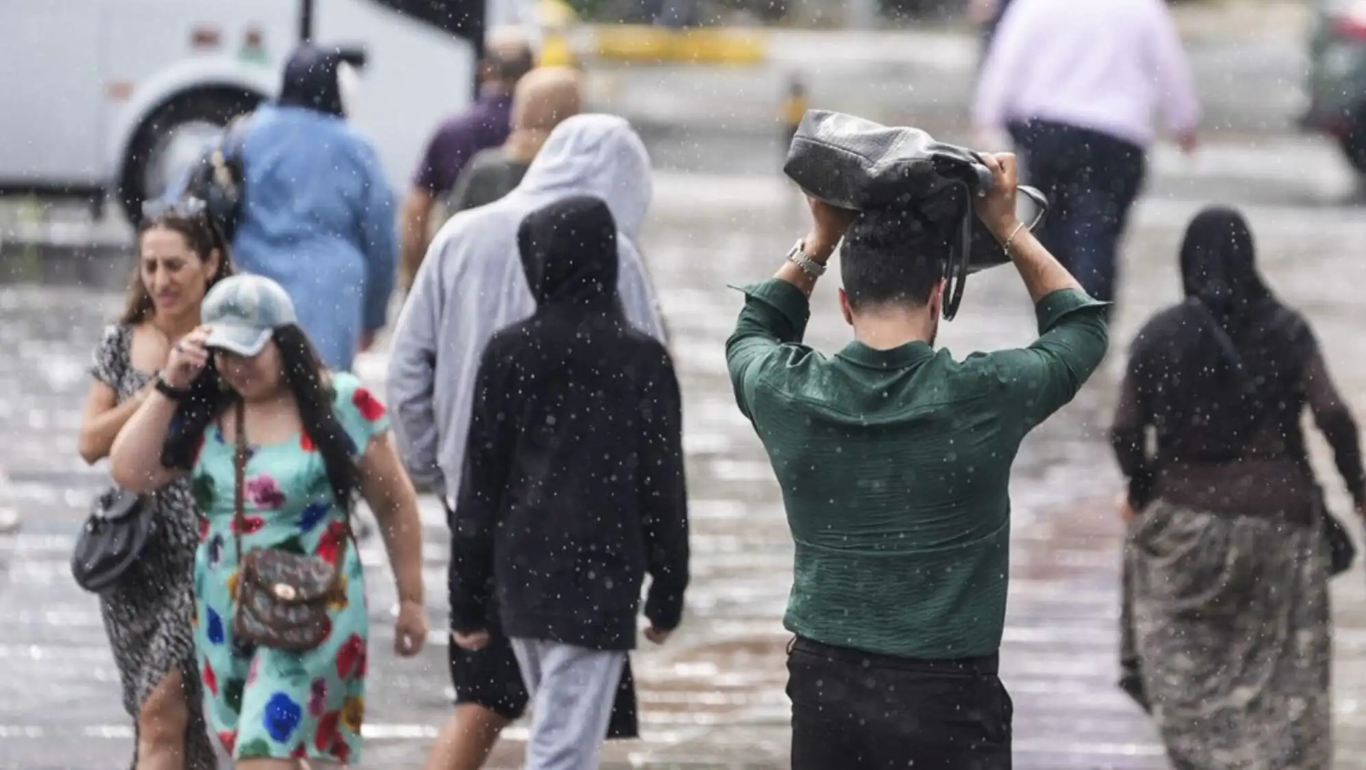 A man holding a bag on his head while walking in the rain.