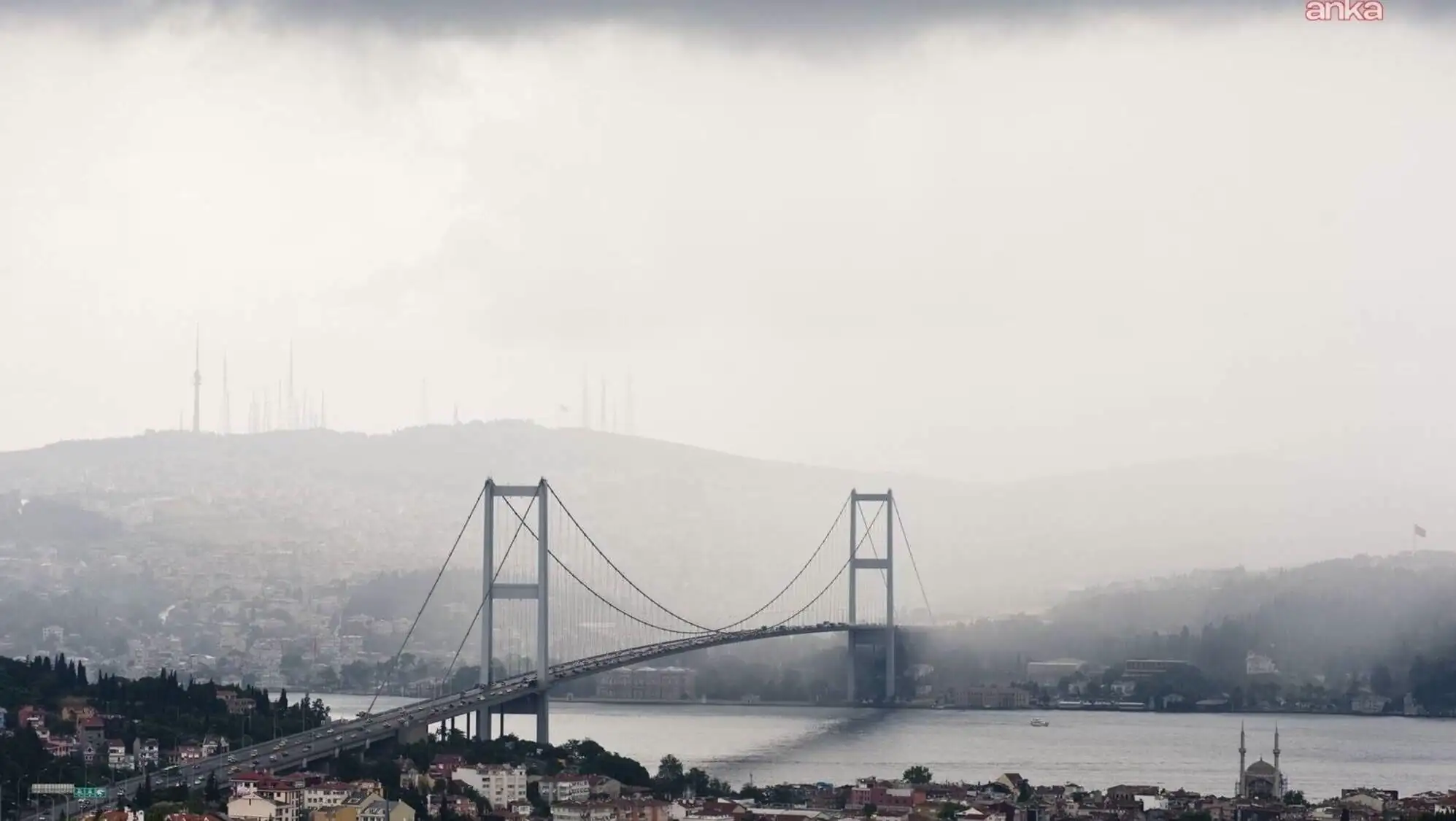 A bridge over water with a city in the background.