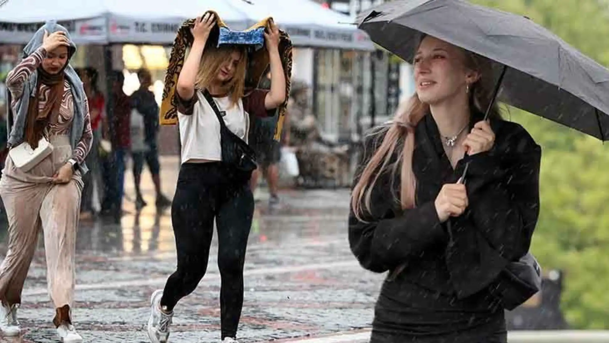 Two women holding umbrellas in the rain.