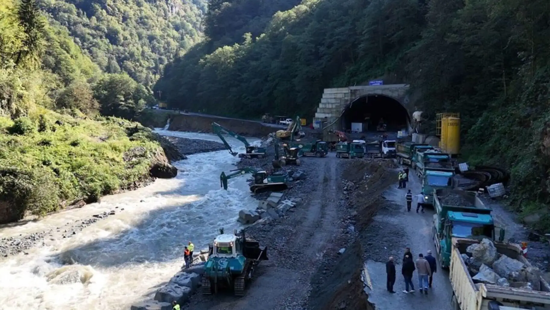 Bir tünelden geçen bir nehir ve inşaat araçları.
