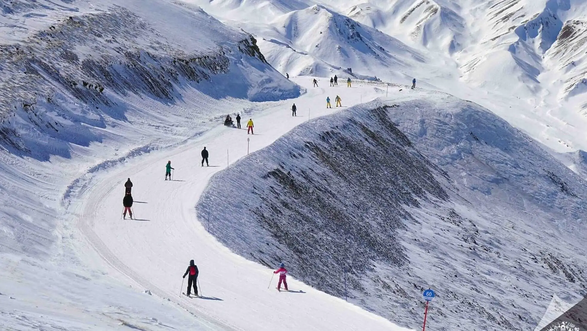 A group of people skiing on a snowy mountain. A group of people skiing on a snowy mountain.