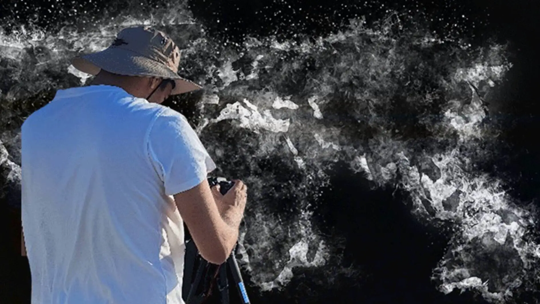 A person with a hat and a camera. A person with a hat and a camera.