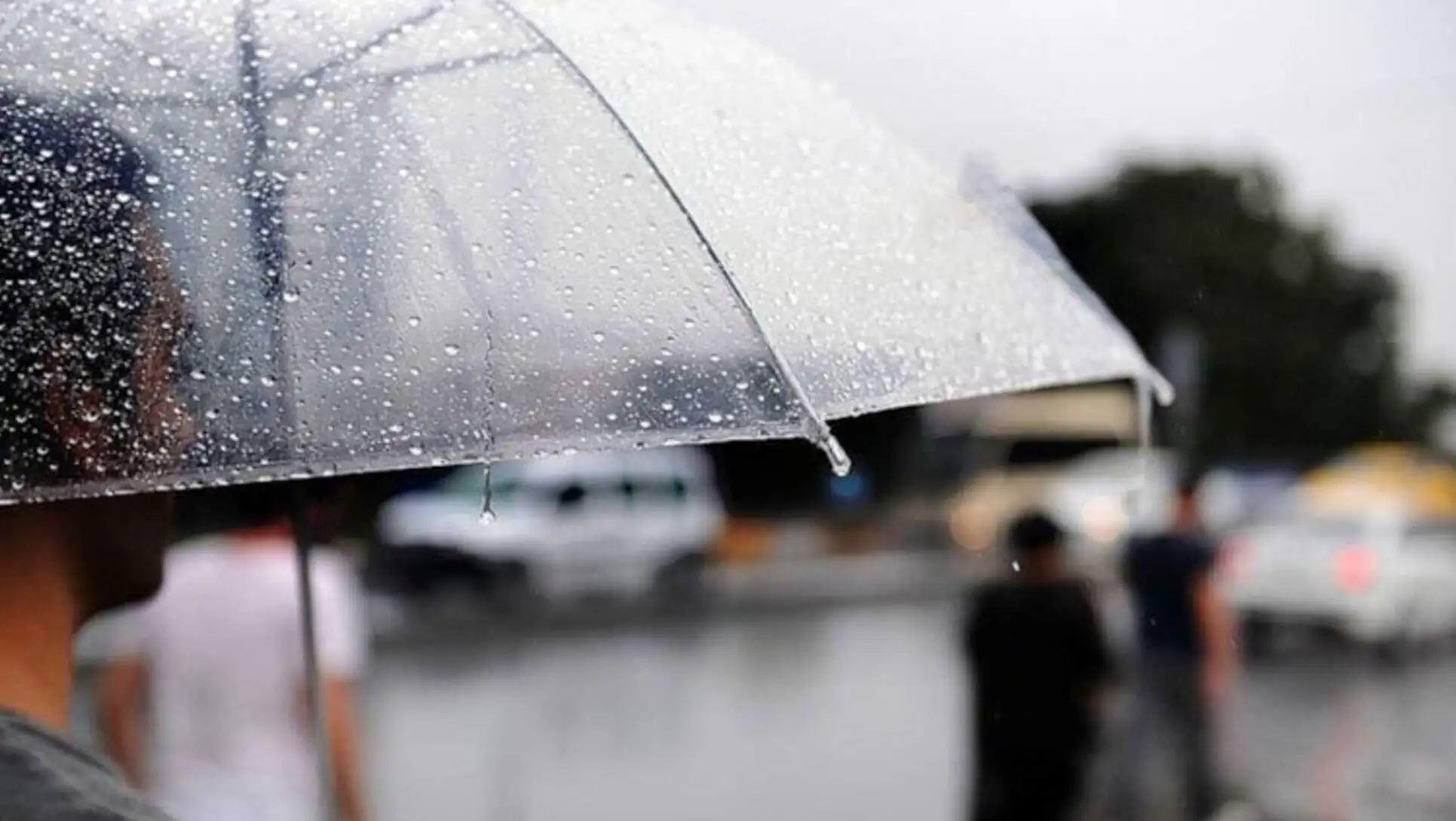 A person holding an umbrella in the rain. A person holding an umbrella in the rain.