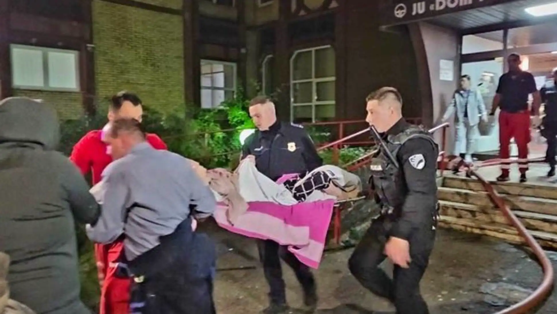 Bir grup insan, bir kişiyi yatakta taşıyor. Bir grup insan, bir kişiyi yatakta taşıyor.