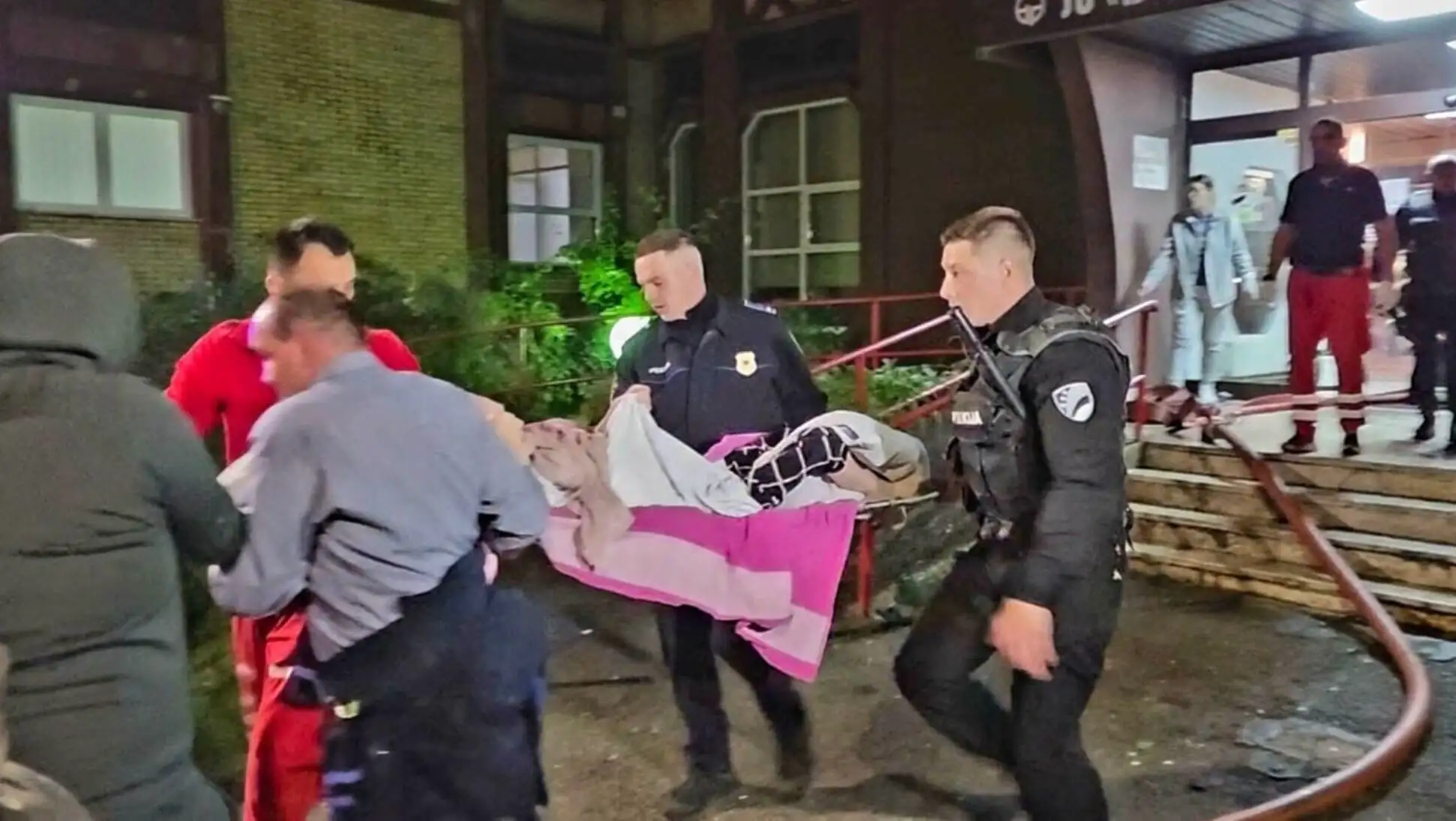 A group of police officers carrying a person in a bed. A group of police officers carrying a person in a bed.