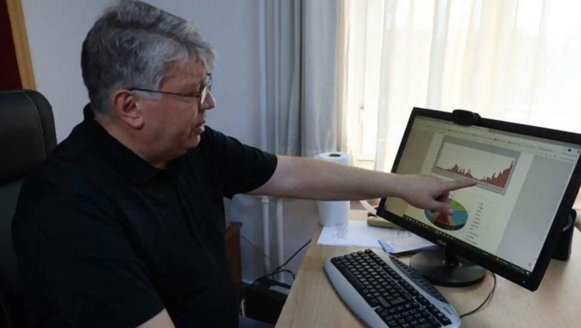 A man pointing at a computer screen.