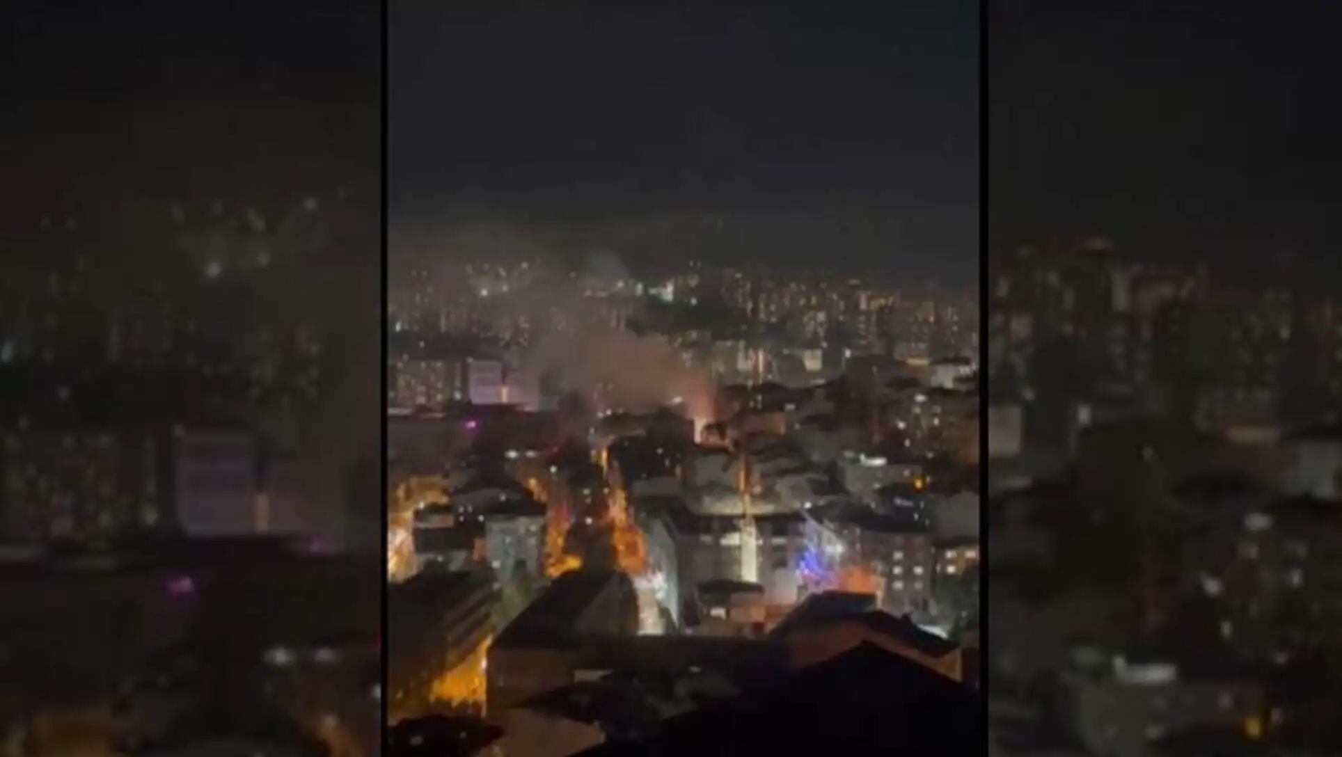 A city at night with smoke coming out of it after the explosion.