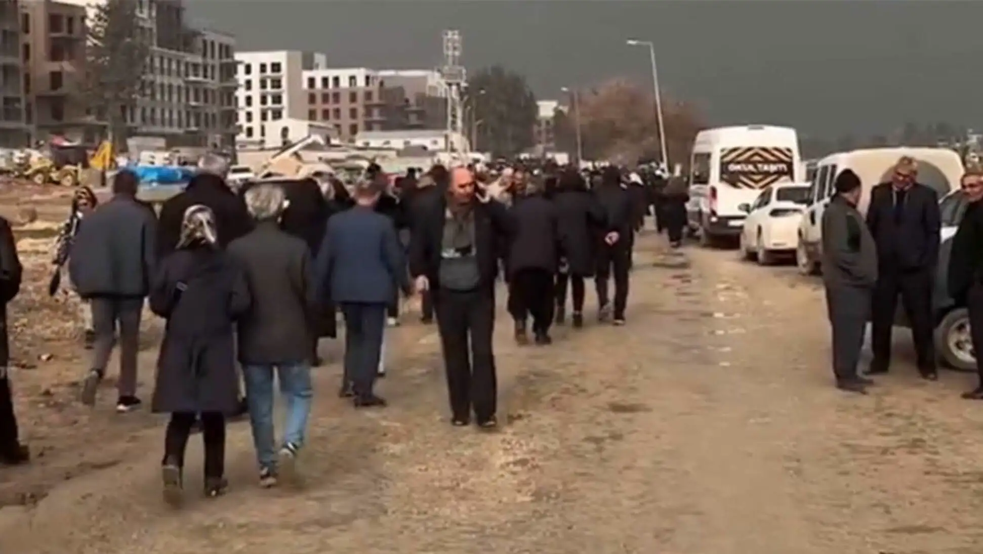 A group of people walking on a dirt road. A group of people walking on a dirt road.