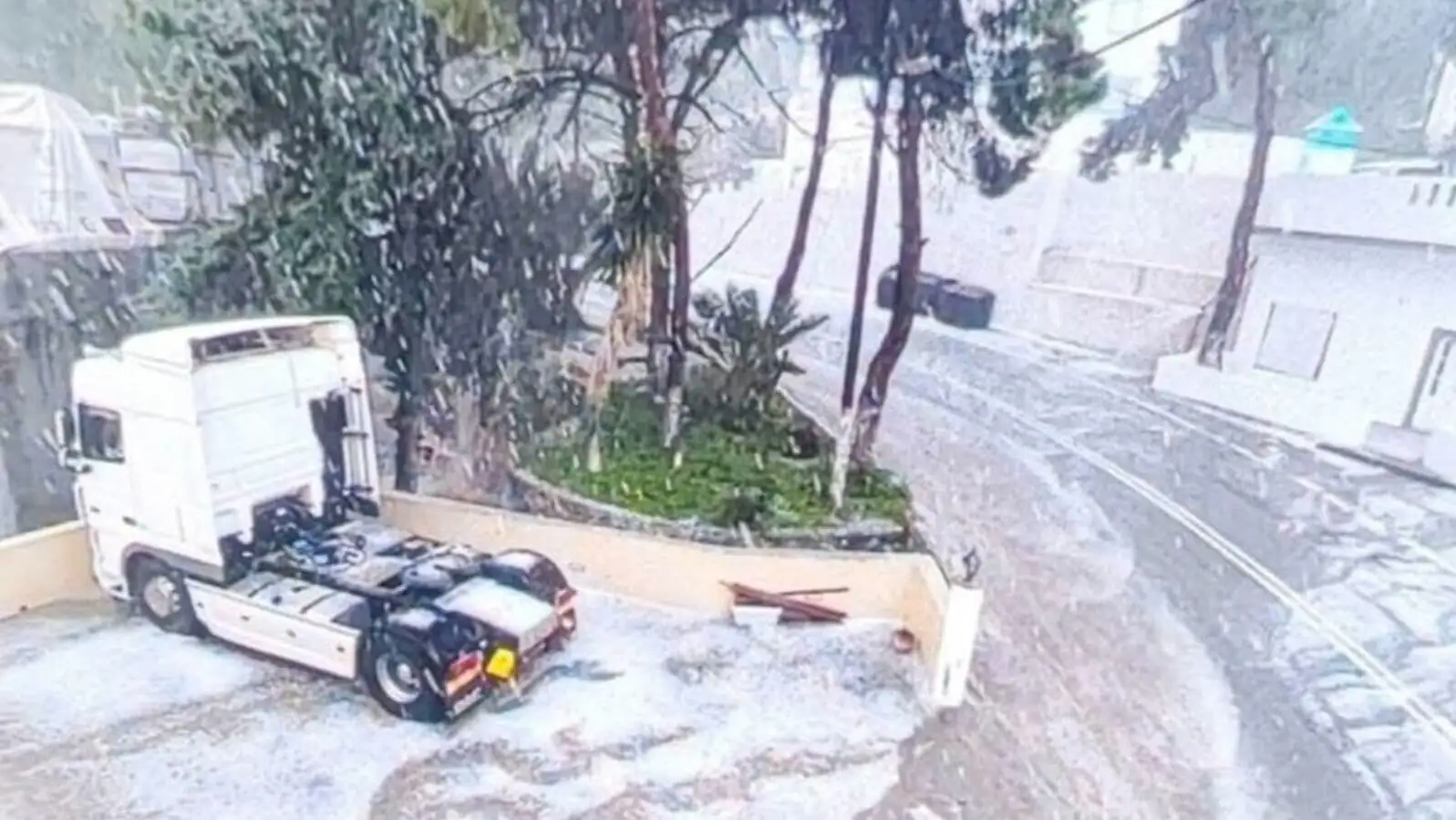 A truck parked on a road in the snow.