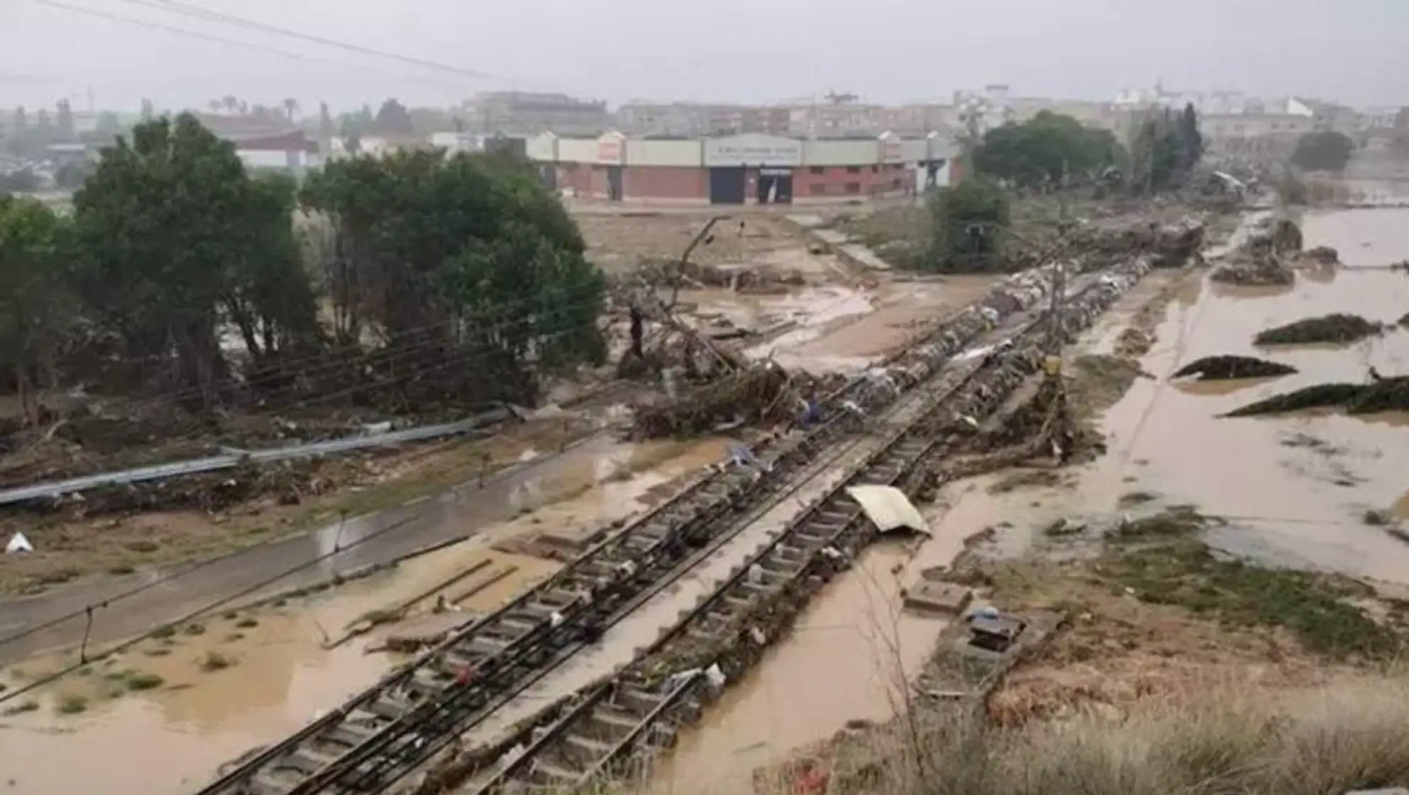 Flooded railroad tracks with debris.