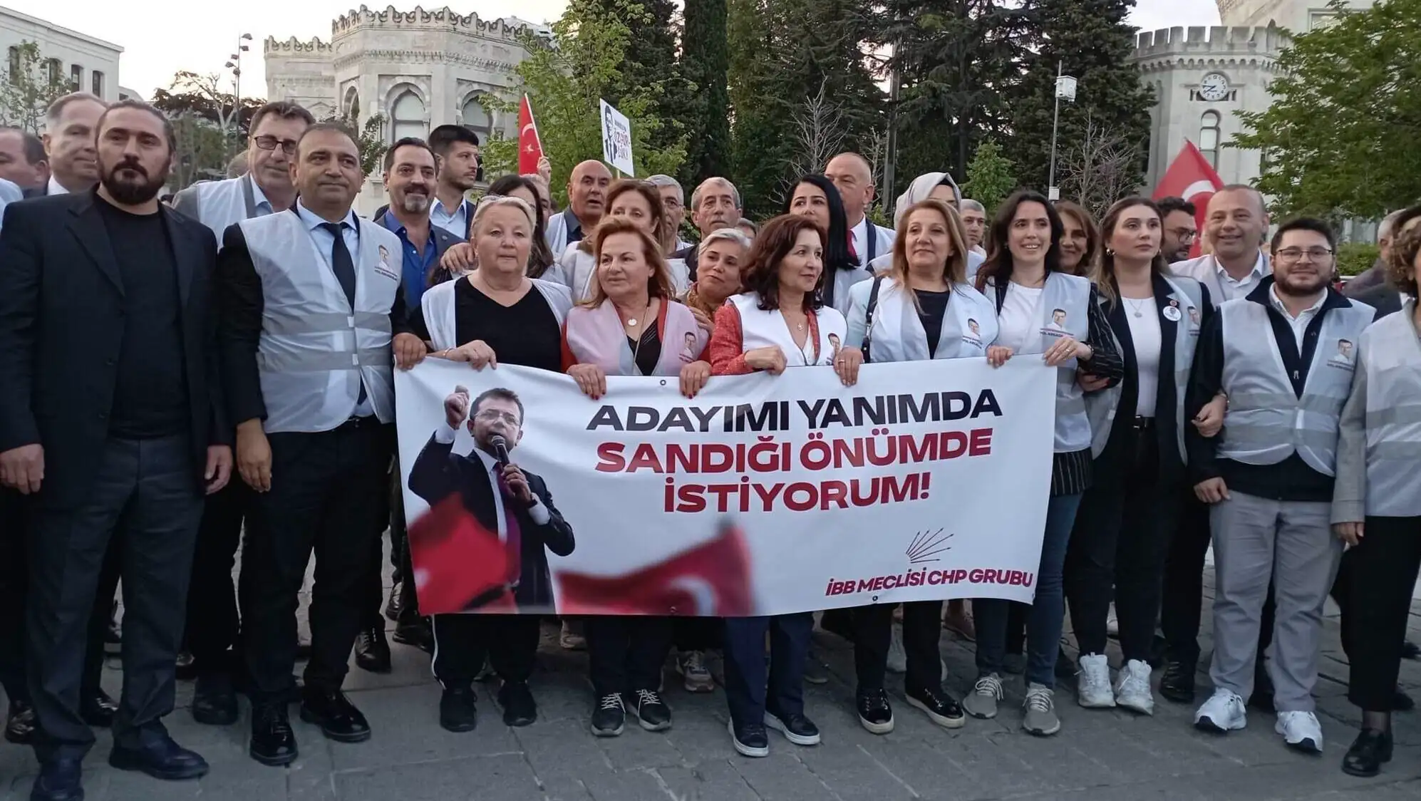 Mitingde kalabalık bir grup, pankartlar tutuyor. Mitingde kalabalık bir grup, pankartlar tutuyor.