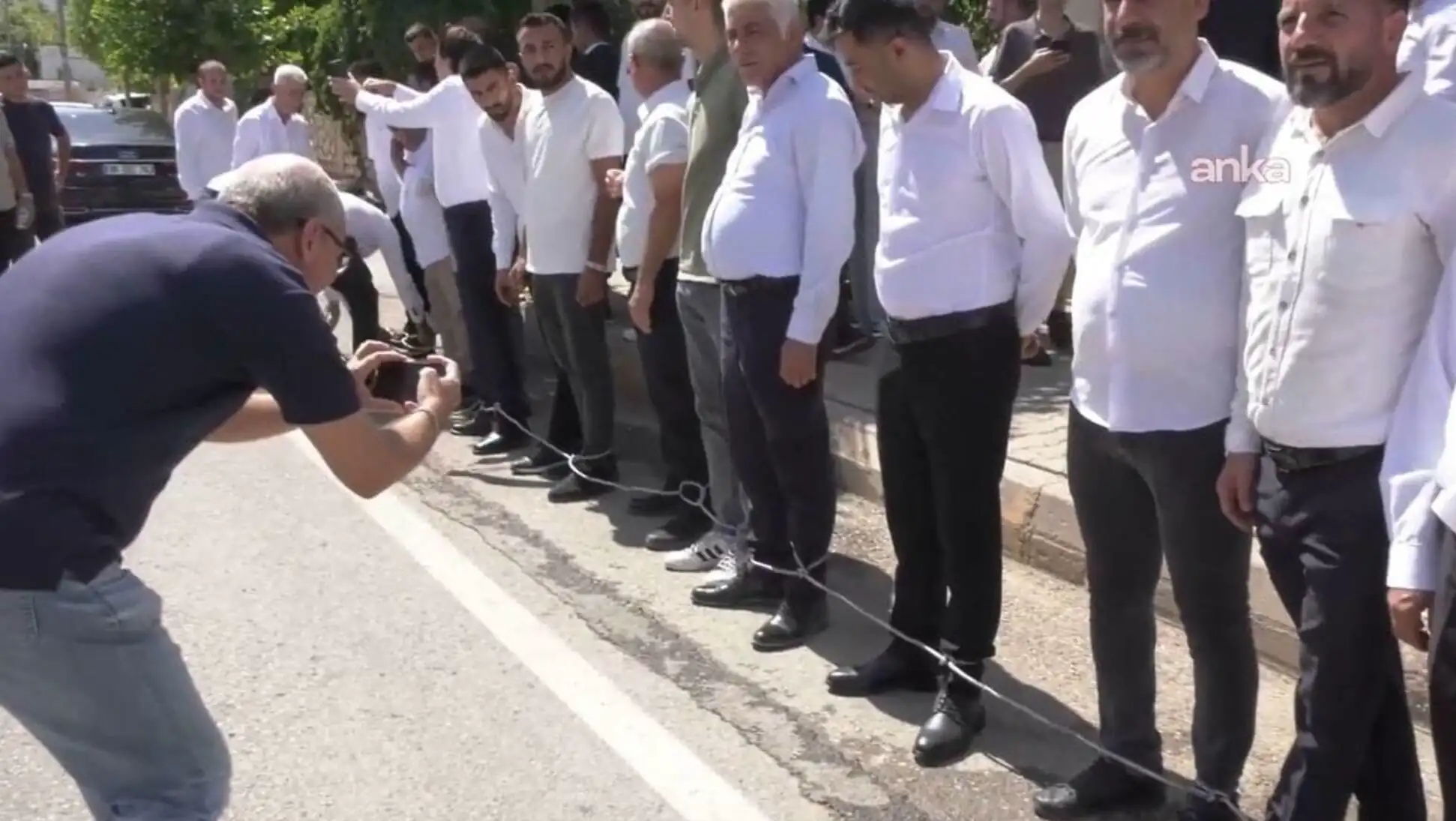 Özgür Özel, kalabalık bir grup insanın fotoğrafını çekiyor. Özgür Özel, kalabalık bir grup insanın fotoğrafını çekiyor.