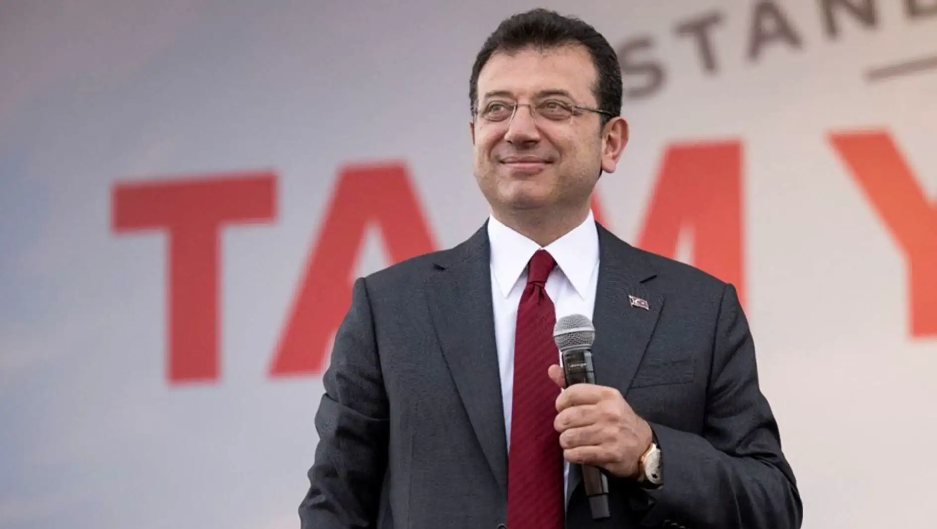 Ekrem İmamoğlu speaking into a microphone in court. Ekrem İmamoğlu speaking into a microphone in court.
