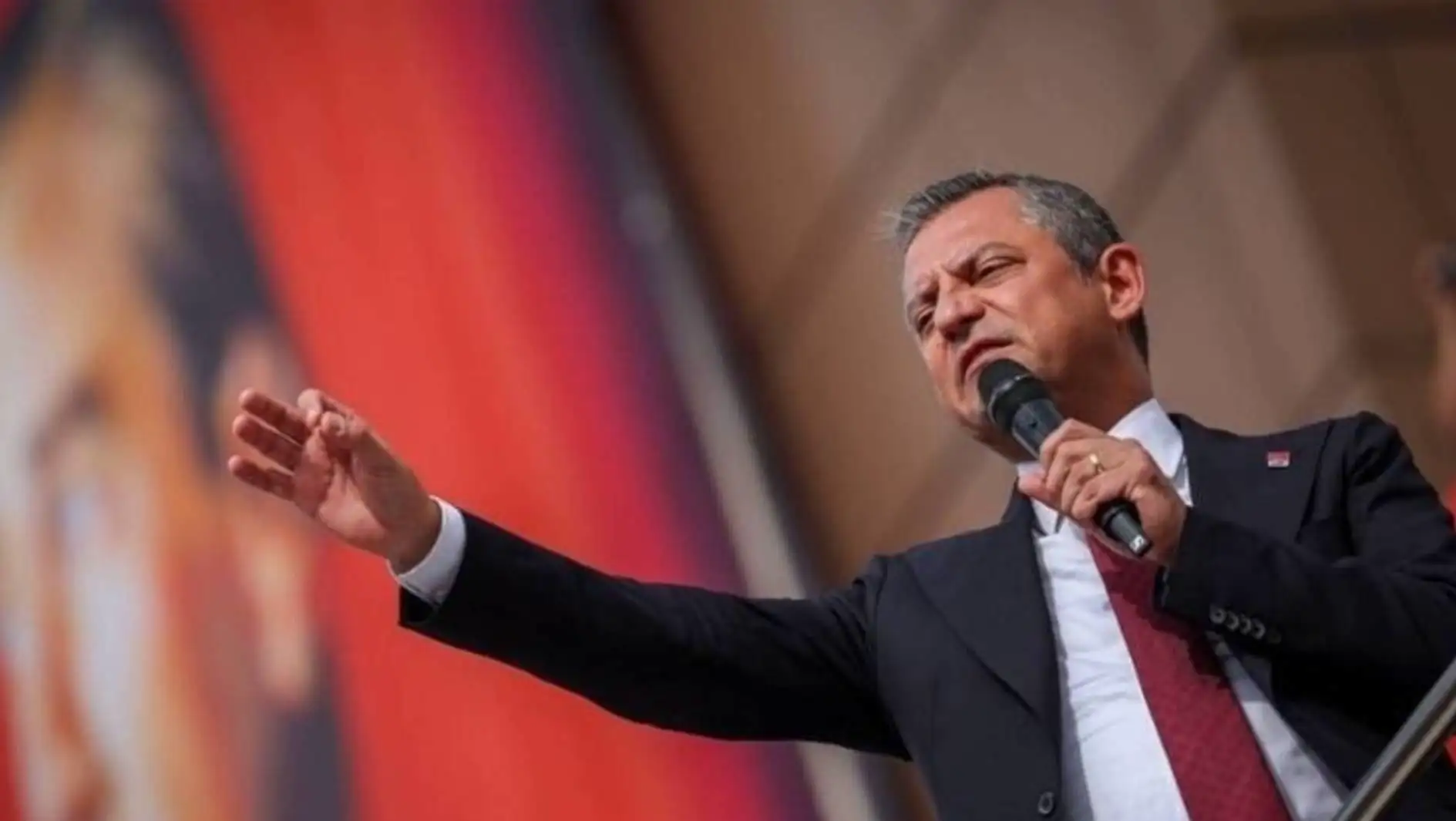 CHP leader Özgür Özel speaking into a microphone at the rally. CHP leader Özgür Özel speaking into a microphone at the rally.