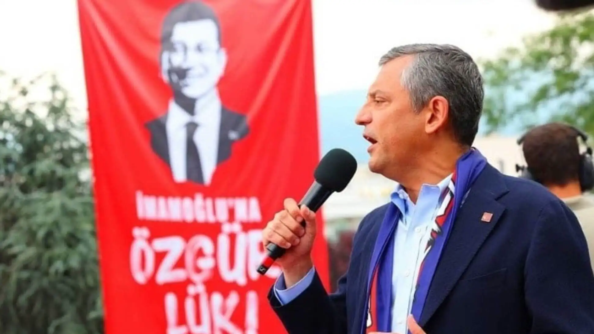 Bir adam mikrofonla konuşuyor.