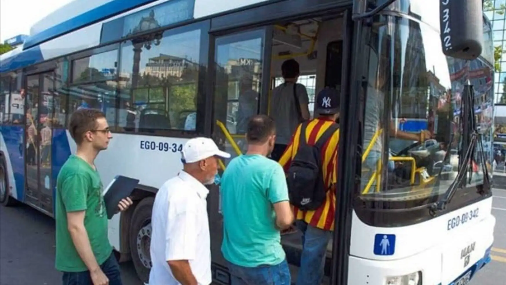 A group of people getting on a bus in Ankara.