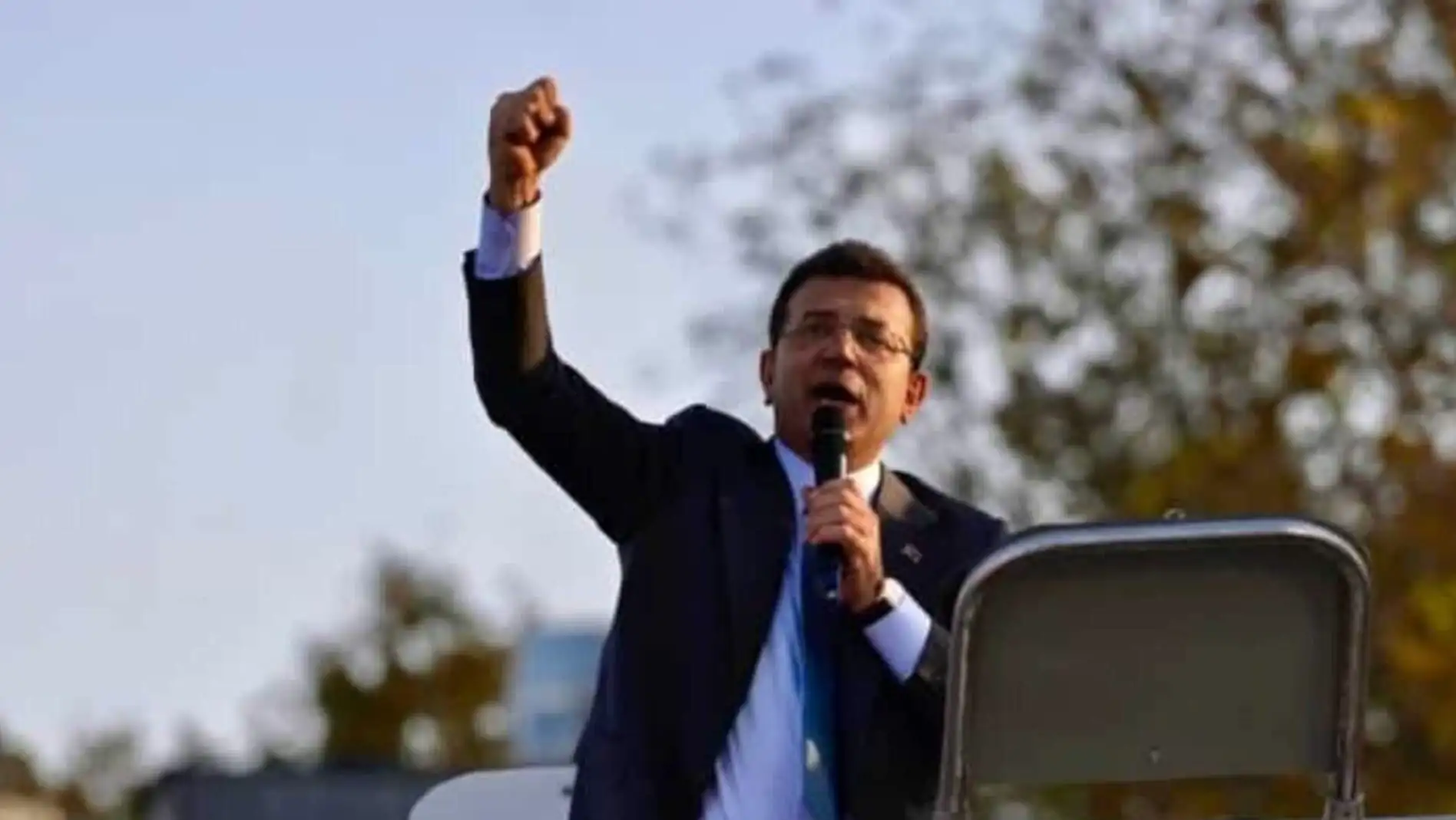 Ekrem İmamoğlu holding a microphone.