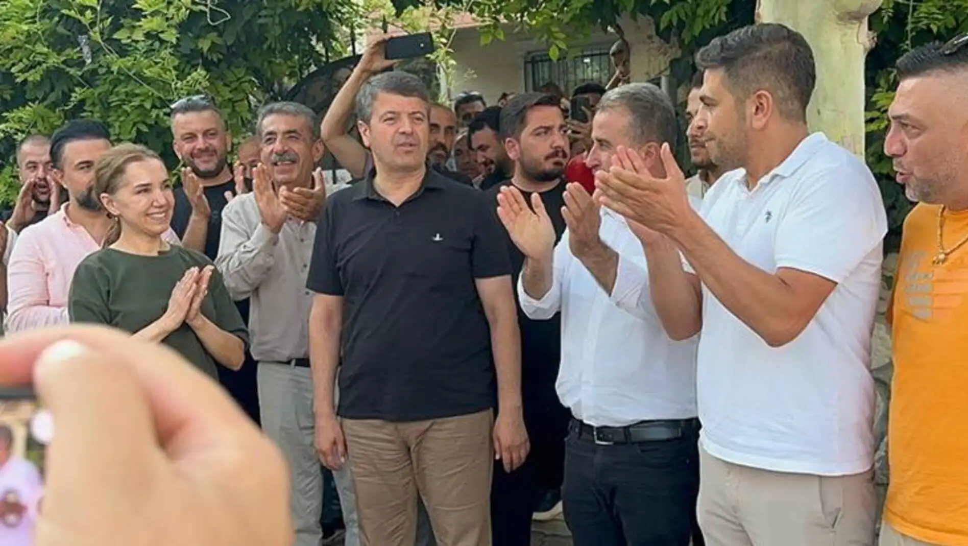 A group of people applauding in support of Abdurrahman Tutdere. A group of people applauding in support of Abdurrahman Tutdere.