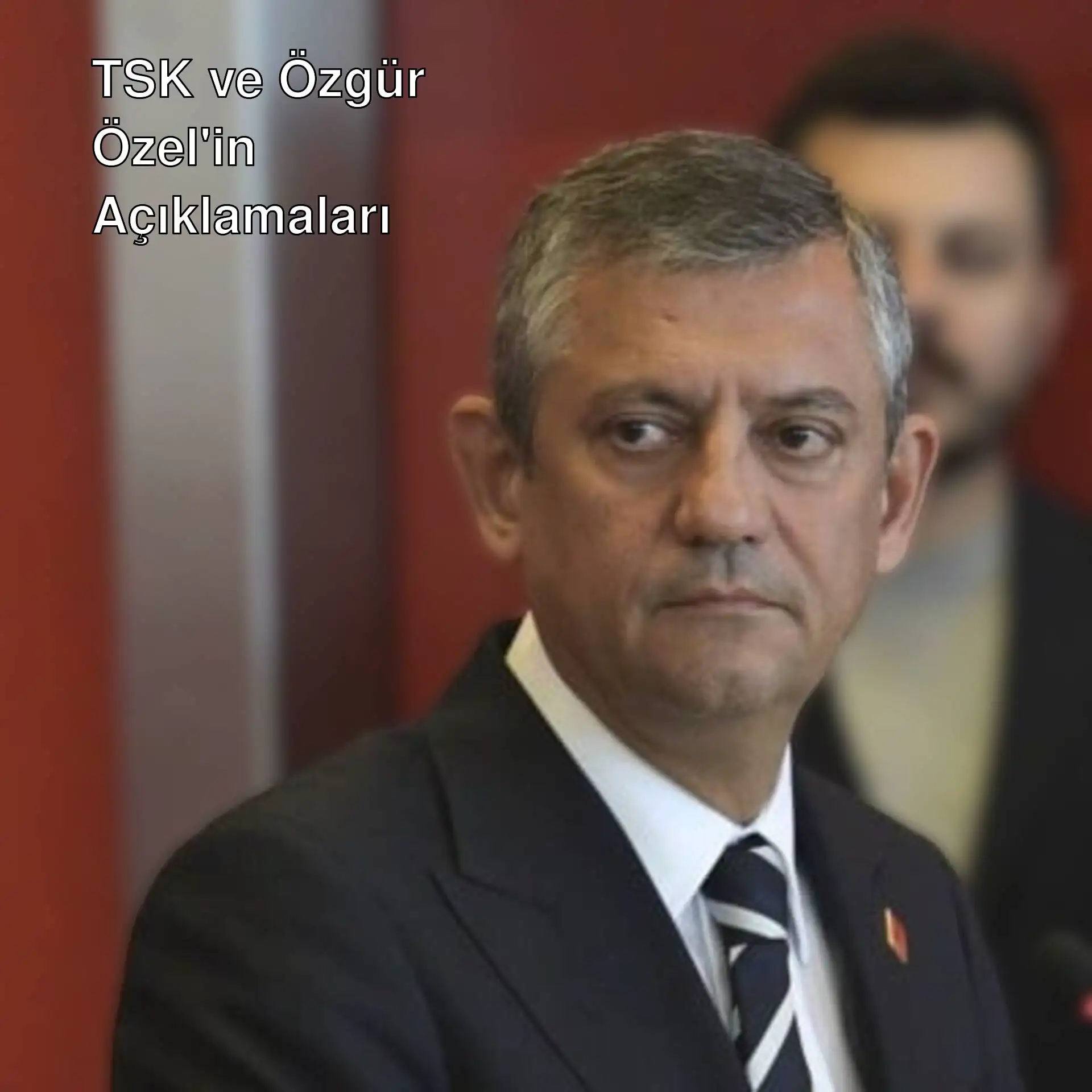 Özgür Özel, resmi bir kıyafetle konuşma yapıyor.