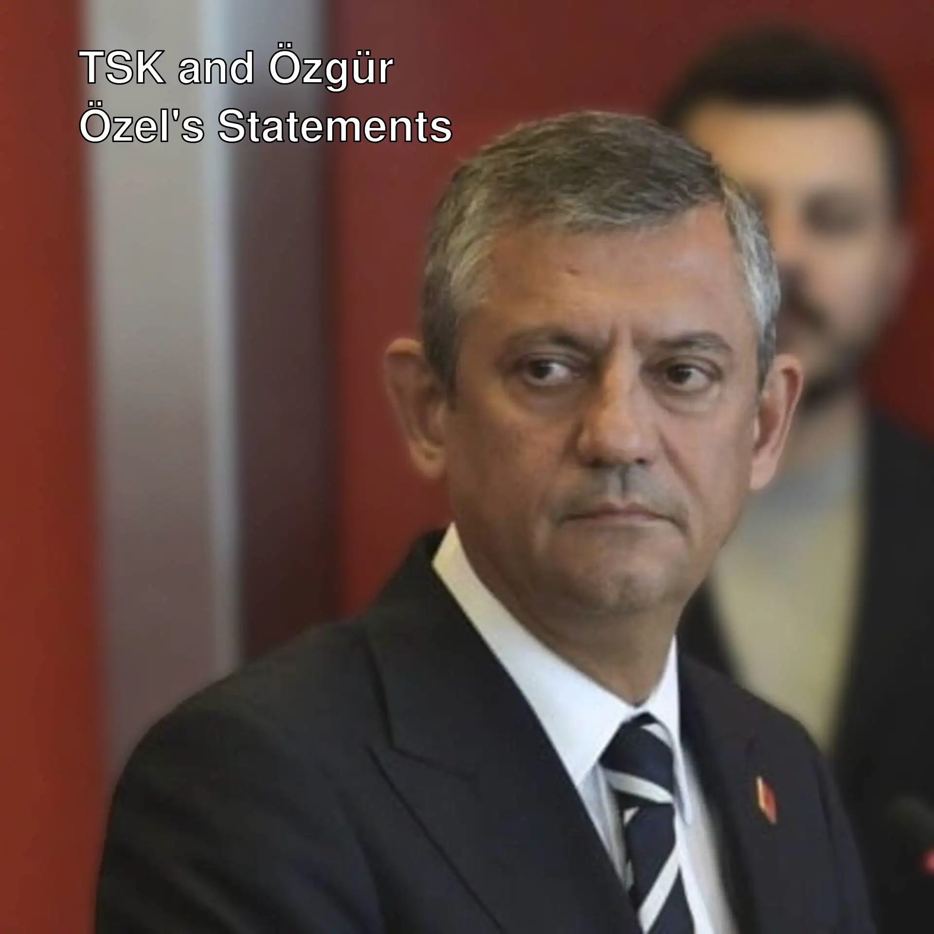 Özgür Özel speaking in formal attire.