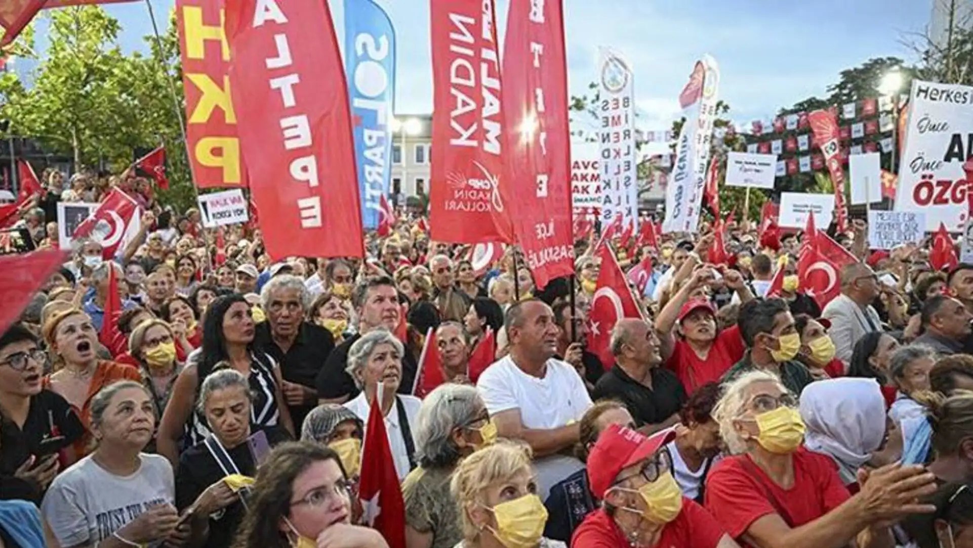 A large group holding flags at the rally. A large group holding flags at the rally.