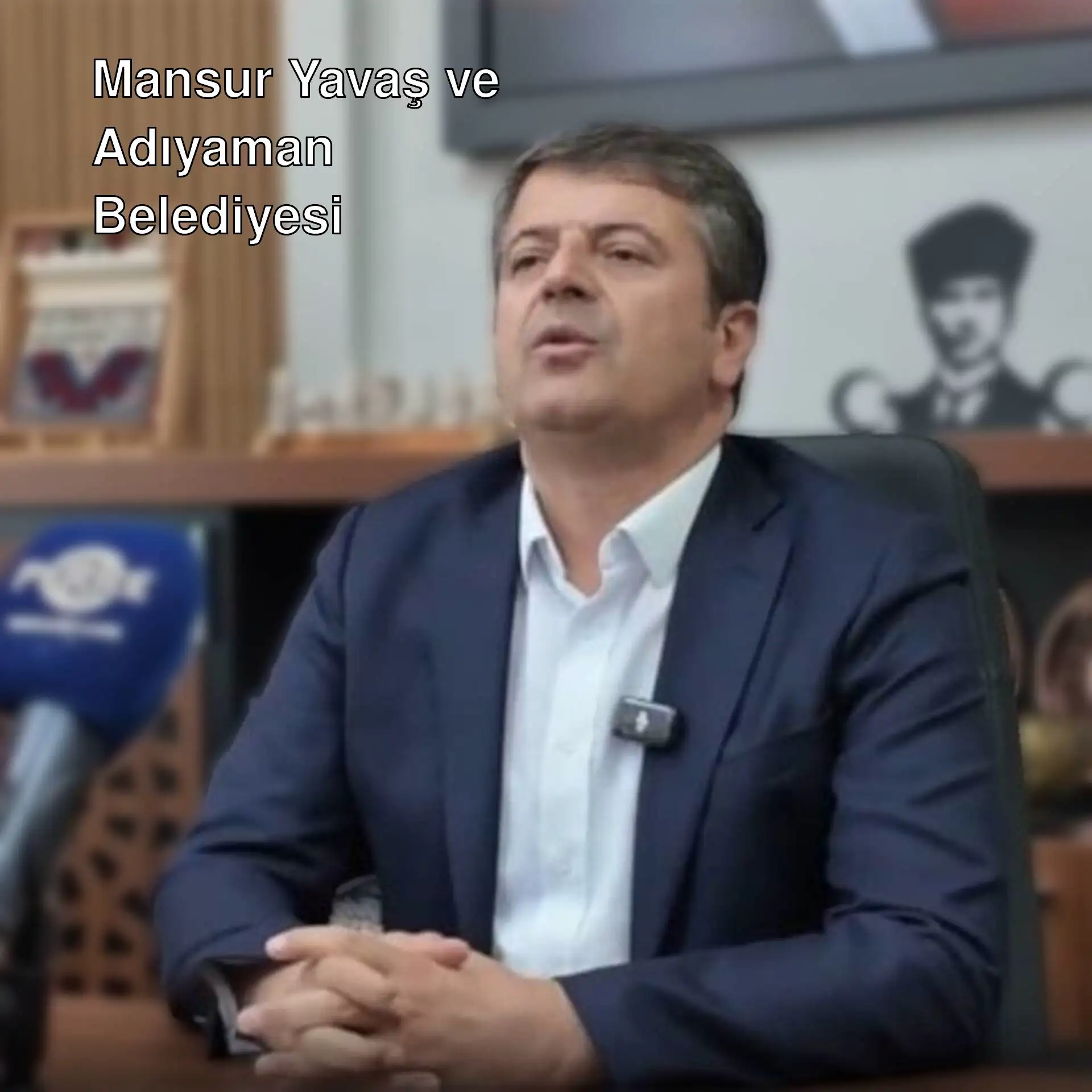 Abdurrahman Tutdere, mikrofonla bir masada oturuyor. Abdurrahman Tutdere, mikrofonla bir masada oturuyor.