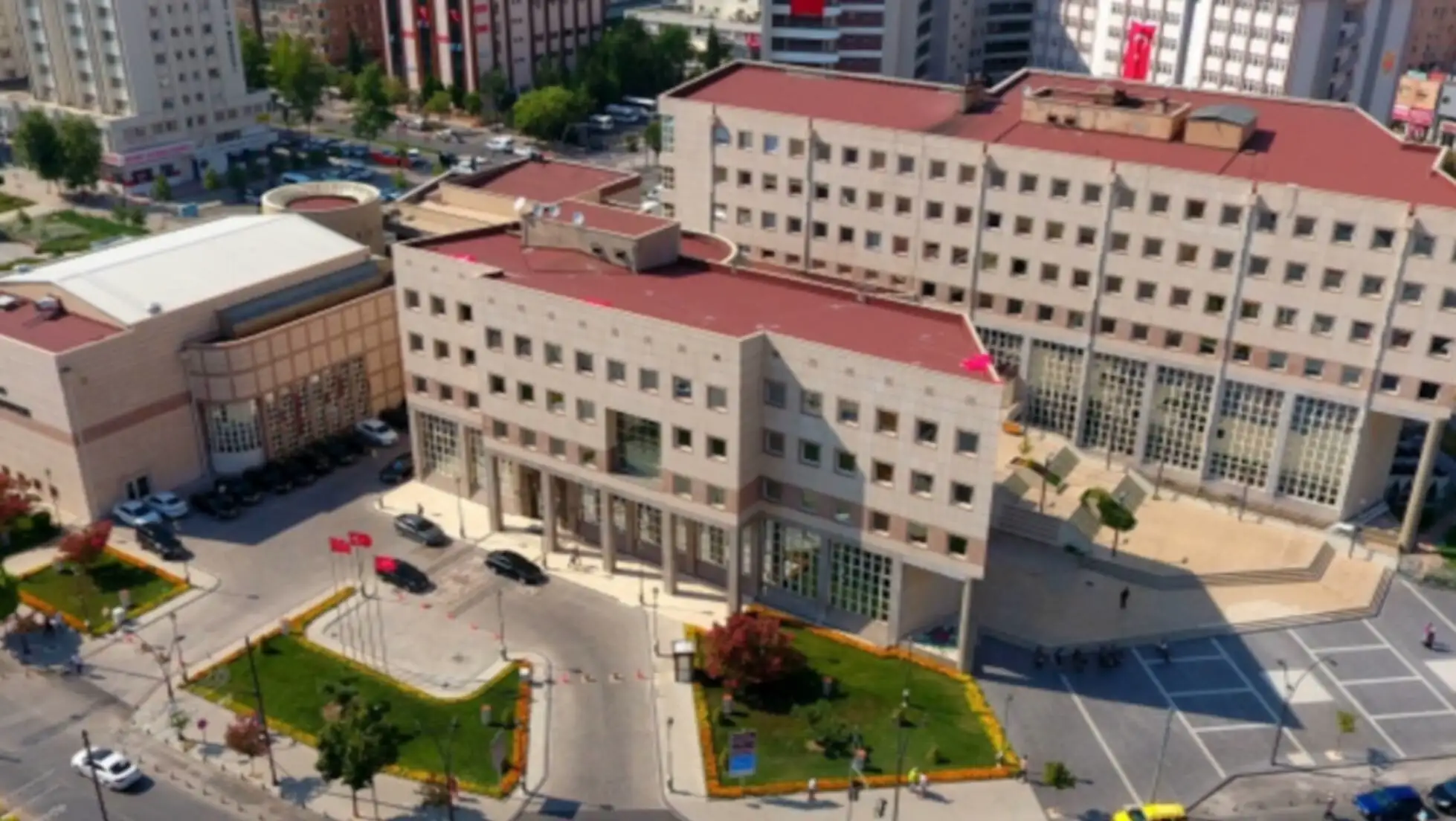 Bir bina ve önünde park edilmiş araçlar.