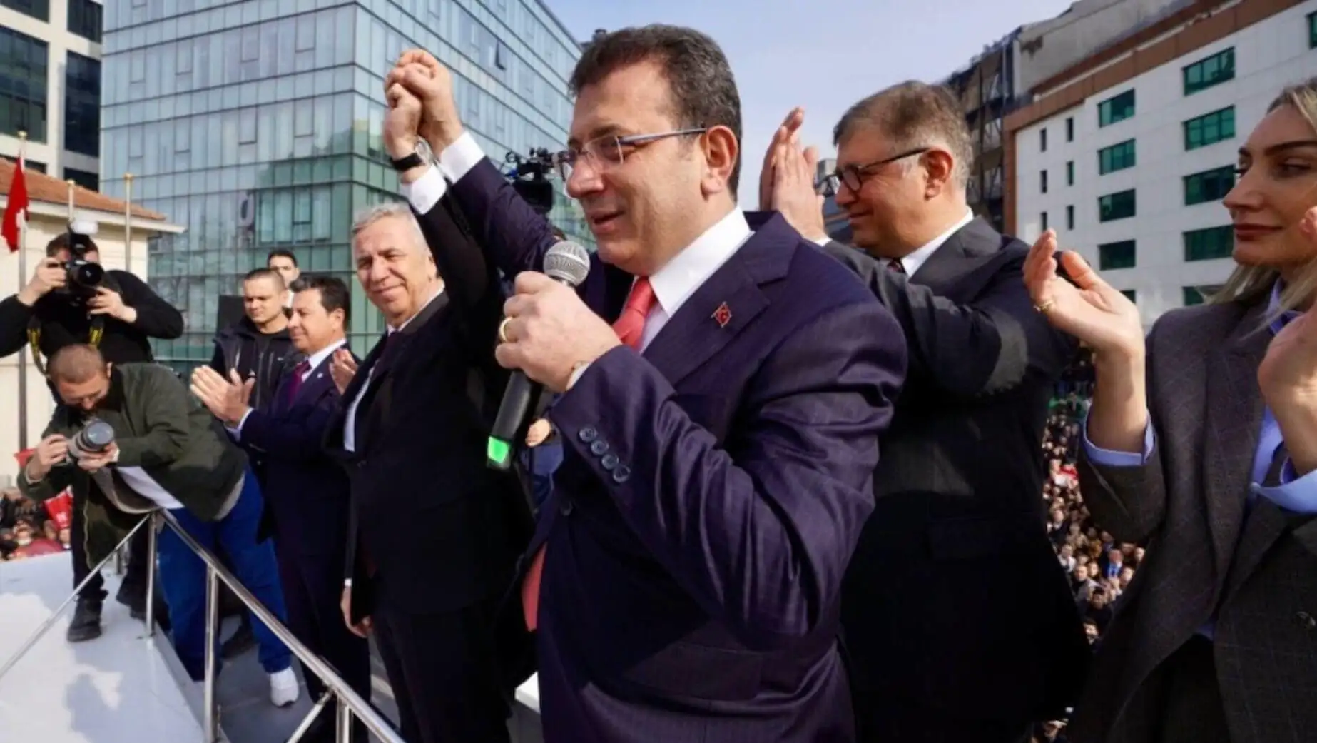 A group of men standing in front of a building. A group of men standing in front of a building.