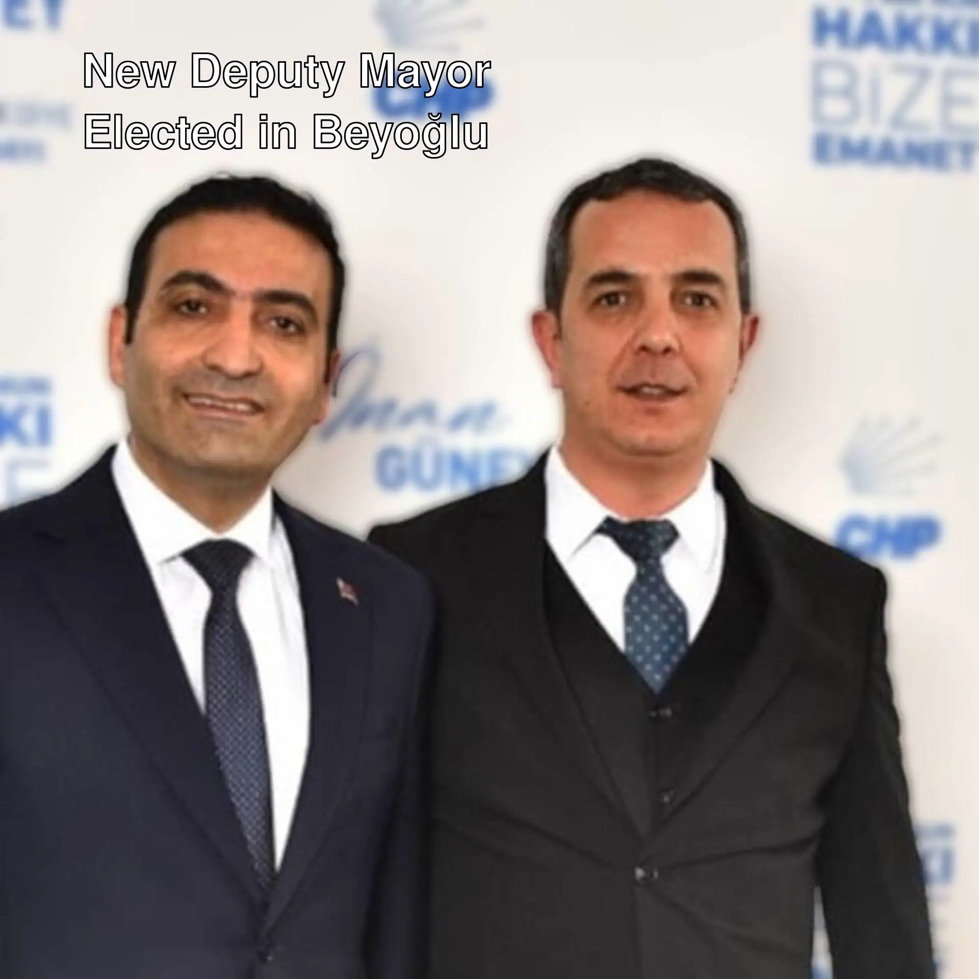 Two men in suits posing for a photo. Two men in suits posing for a photo.