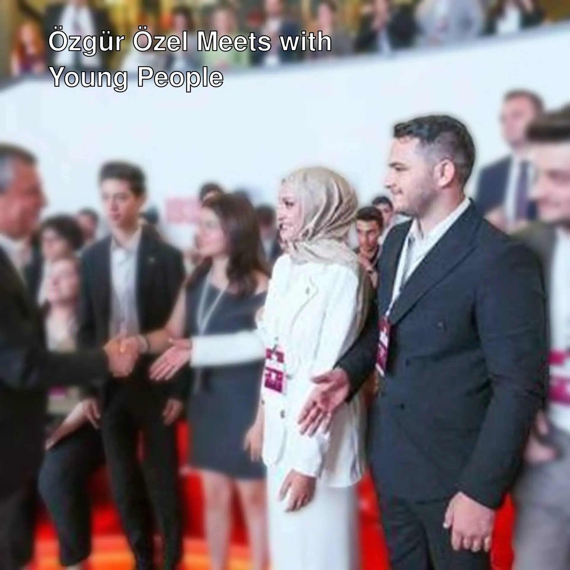 Özgür Özel shaking hands with young people.