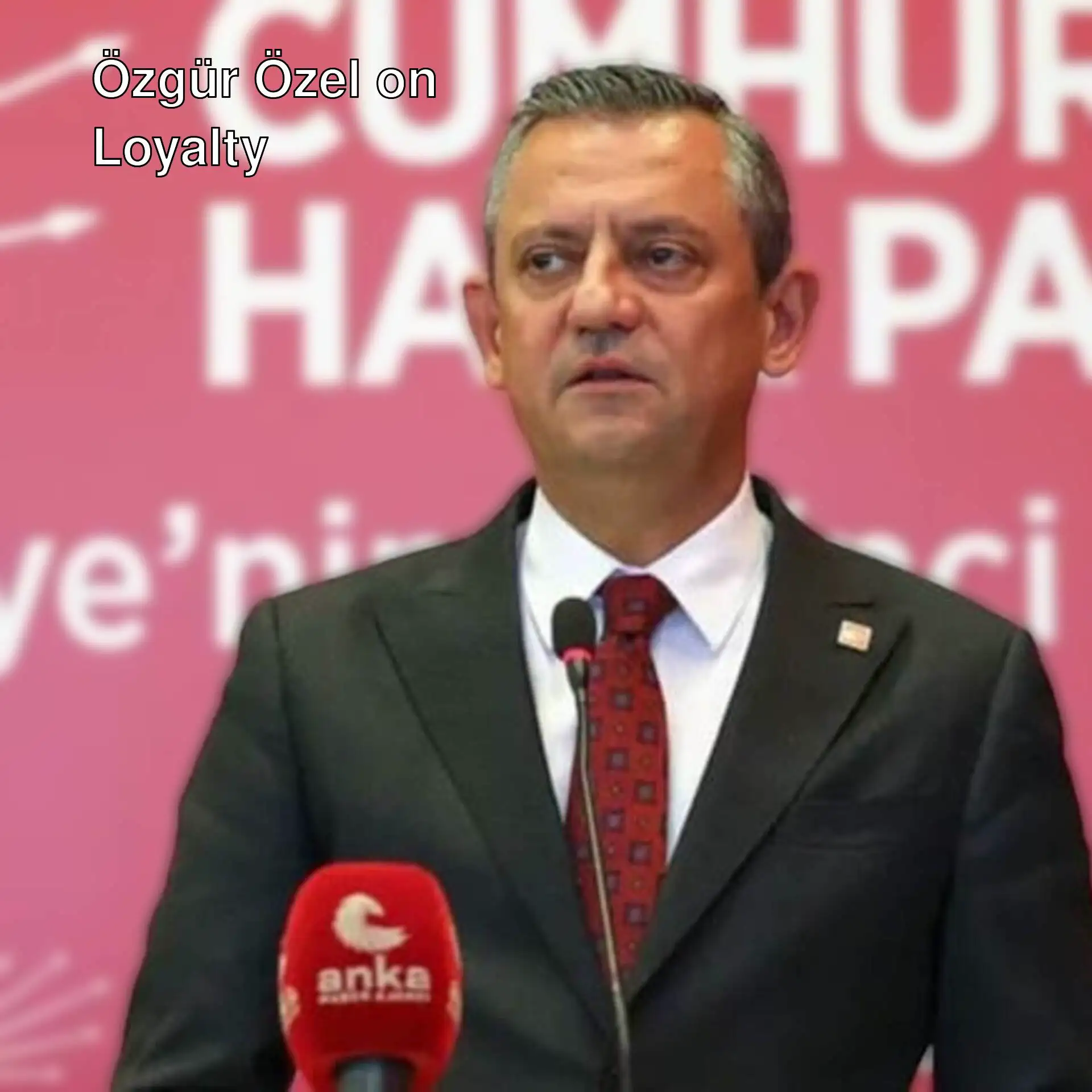 Özgür Özel standing in front of a microphone.